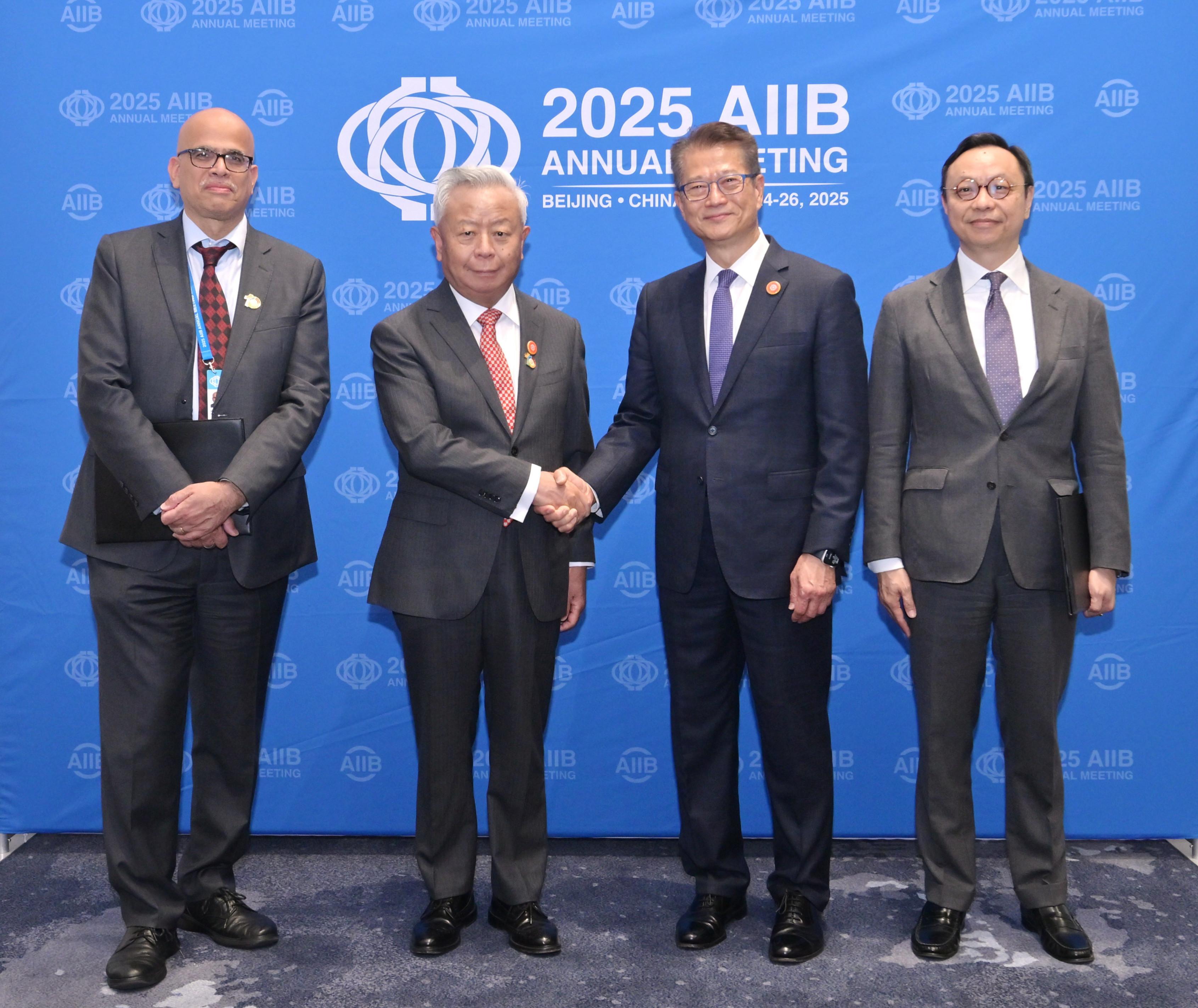 The Financial Secretary, Mr Paul Chan, attended the 10th Annual Meeting of the Board of Governors of the Asian Infrastructure Investment Bank (AIIB) in Beijing today (June 26). Photo shows Mr Chan (second right) and the President of the AIIB, Mr Jin Liqun (second left), with Deputy Chief Executive of the Hong Kong Monetary Authority Mr Darryl Chan (first right) and the Acting Chief Investment Officer of the AIIB, Mr Rajat Misra (first left), after their signing of a partnership agreement.