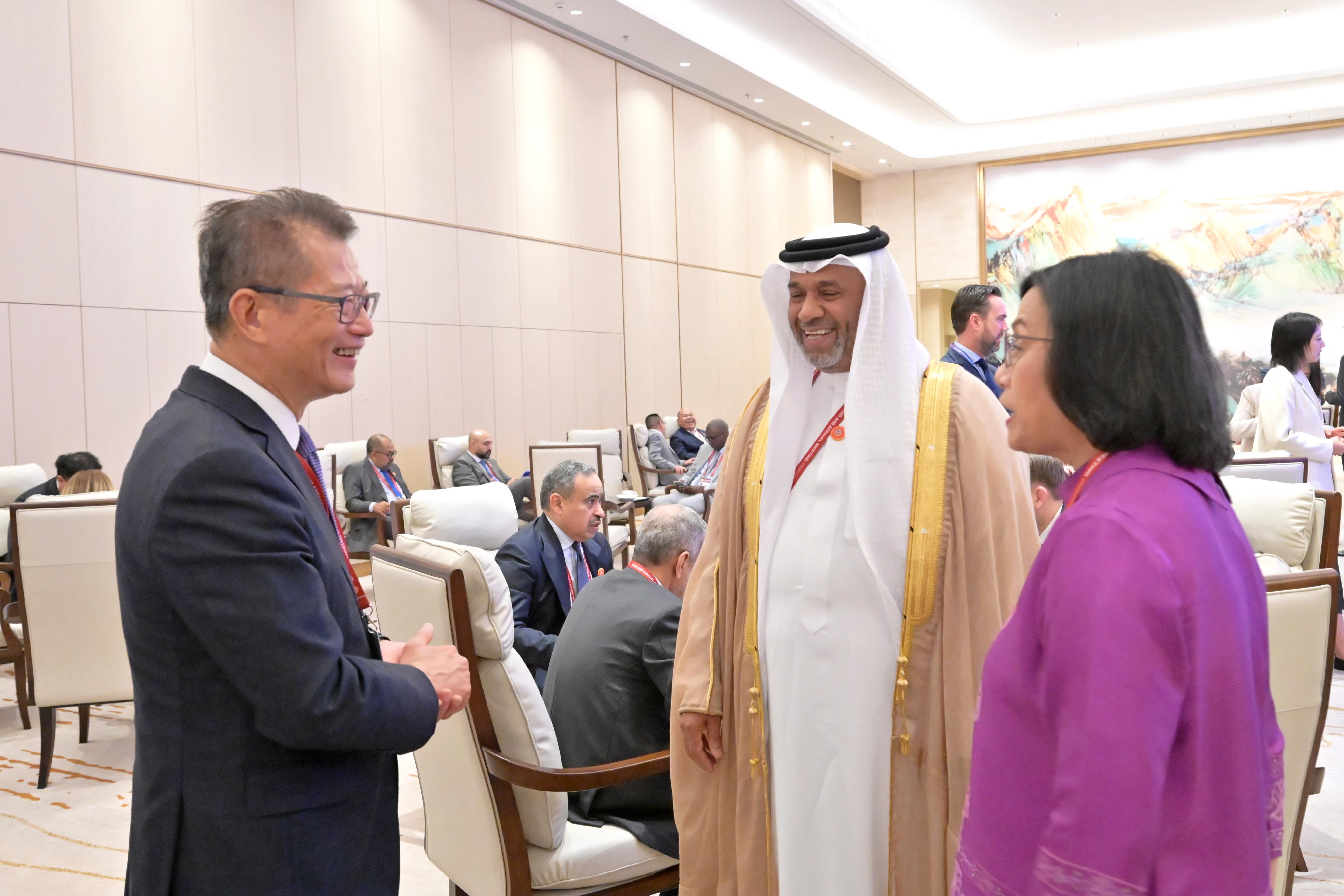 The Financial Secretary, Mr Paul Chan, attended the 10th Annual Meeting of the Board of Governors of the Asian Infrastructure Investment Bank in Beijing today (June 26). Photo shows Mr Chan (left) interacting with other attending governors during the meeting.