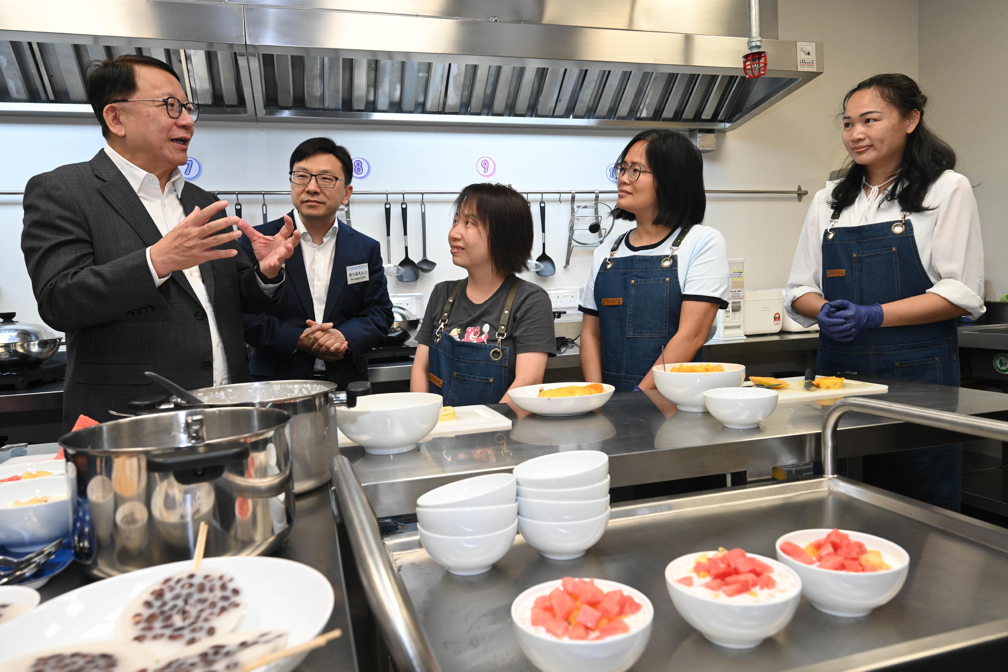 政務司司長陳國基今日（六月三十日）主持深水埗東社區客廳開幕典禮。中央人民政府駐香港特別行政區聯絡辦公室（中聯辦）副主任祁斌、招商局集團董事長繆建民、勞工及福利局局長孫玉菡、中聯辦經濟部副部長郭韶偉、招商局集團董事鍾國東、勞工及福利局常任秘書長劉焱、社會福利署署長杜永恒和博愛醫院董事局主席黃曉君亦一同主禮。圖示陳國基（左一）和孫玉菡（左二）在備餐區與受惠人士交流。