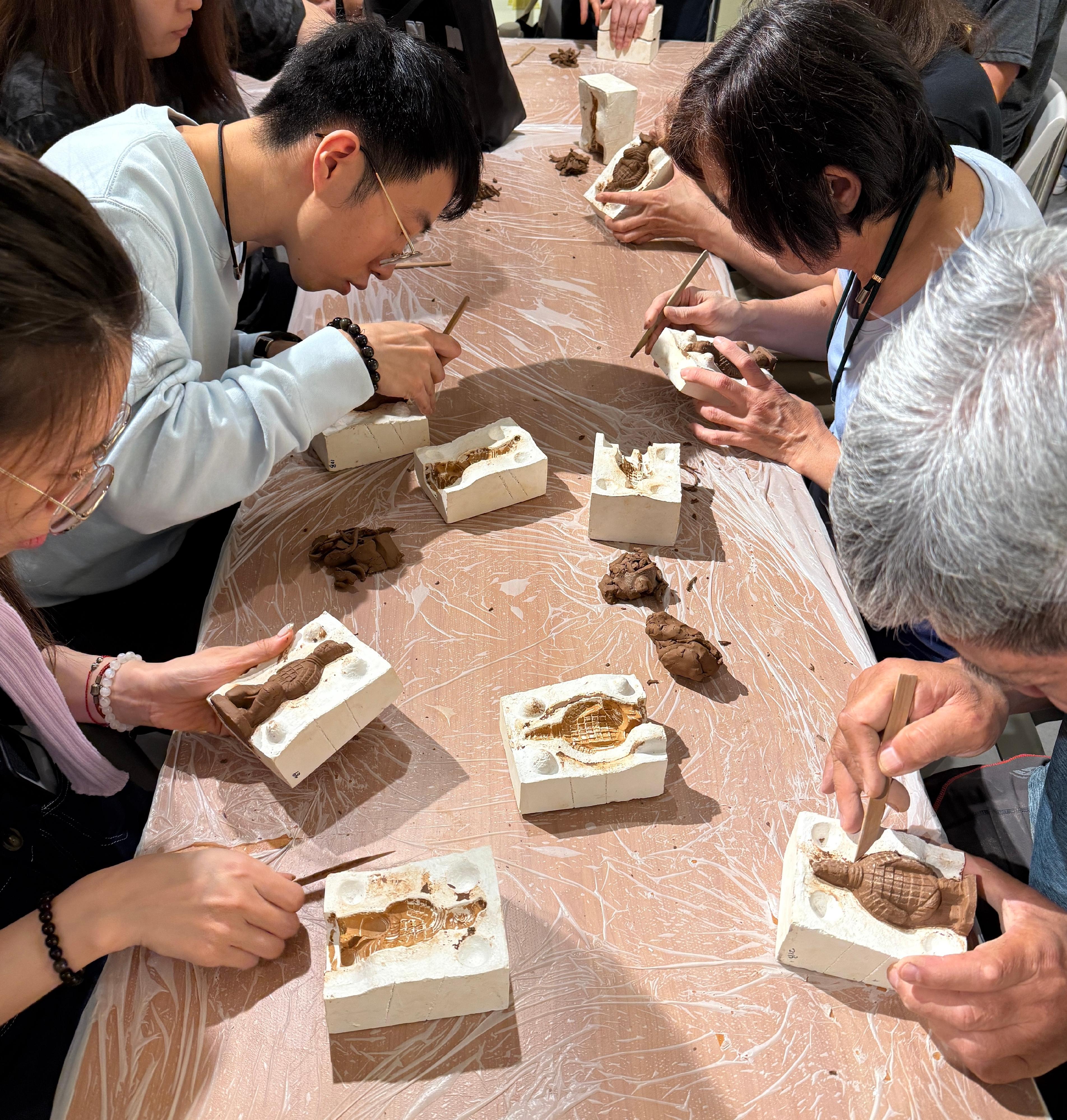 香港歷史博物館的「香港賽馬會呈獻系列：天下一統—陝西秦漢文明展」，自四月十六日開展以來，深受市民及旅客歡迎。展覽今日（六月三十日）迎來第二十萬名參觀者。圖示市民參加博物館的免費迷你秦俑製作工作坊。