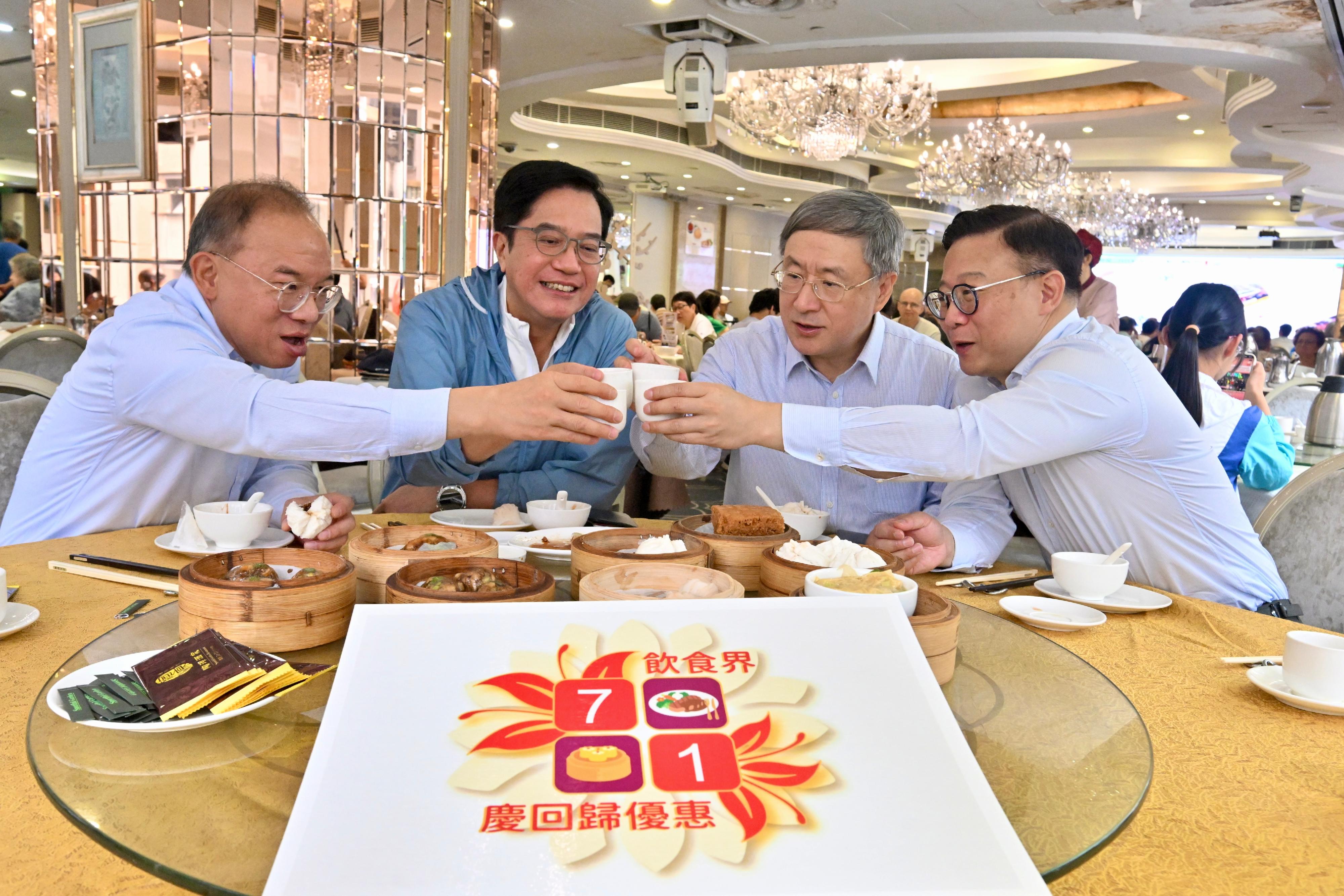 The Deputy Chief Secretary for Administration, Mr Cheuk Wing-hing (second right); the Deputy Financial Secretary, Mr Michael Wong (second left); the Deputy Secretary for Justice, Dr Cheung Kwok-kwan (first right), and the Secretary for Constitutional and Mainland Affairs, Mr Erick Tsang Kwok-wai (first left), raise their glasses to Hong Kong's return to the motherland at a Chinese restaurant in Wan Chai today (July 1).