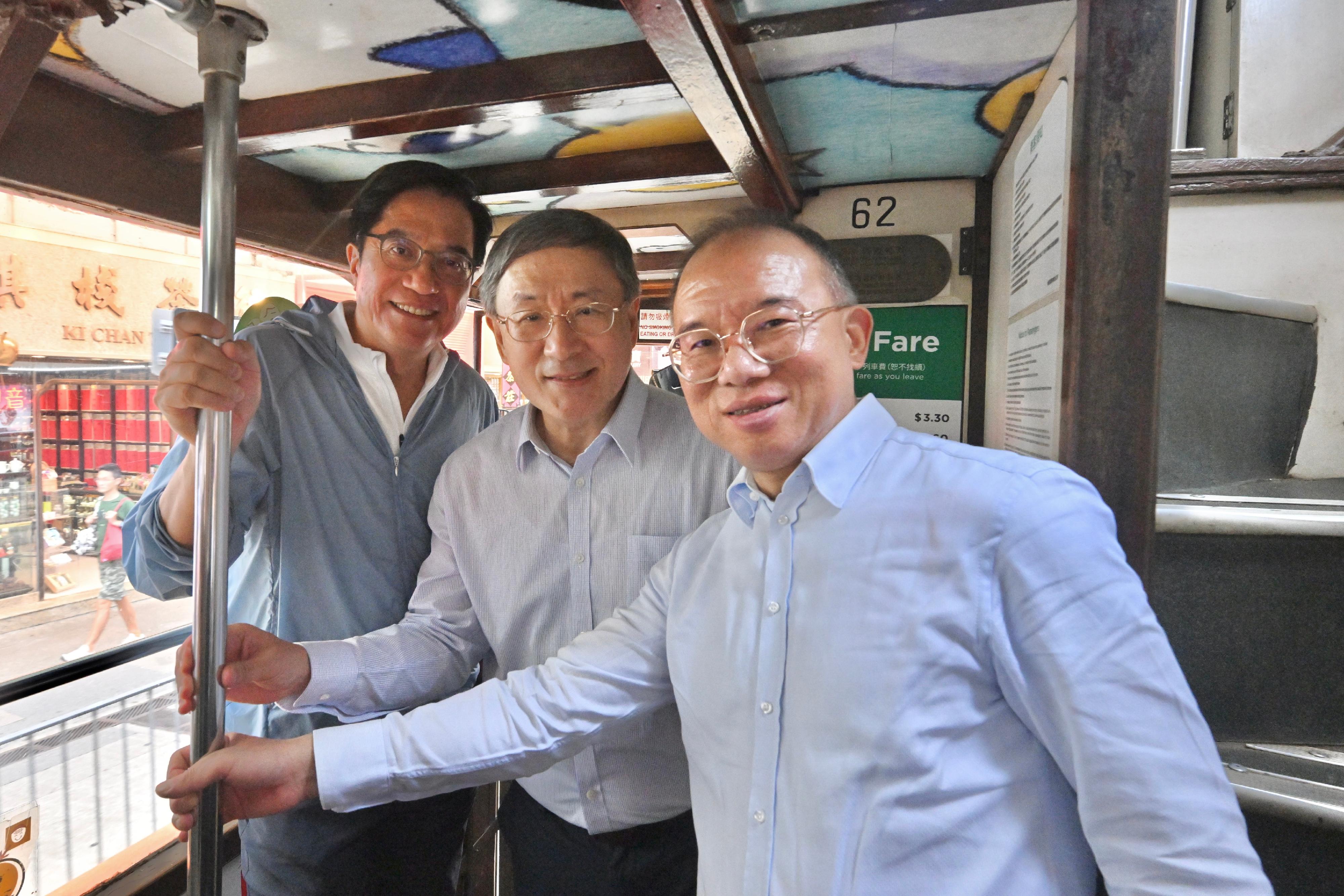 The Deputy Chief Secretary for Administration, Mr Cheuk Wing-hing (centre); the Deputy Financial Secretary, Mr Michael Wong (left); and the Secretary for Constitutional and Mainland Affairs, Mr Erick Tsang Kwok-wai (right), take a free tram ride in Wan Chai today (July 1).