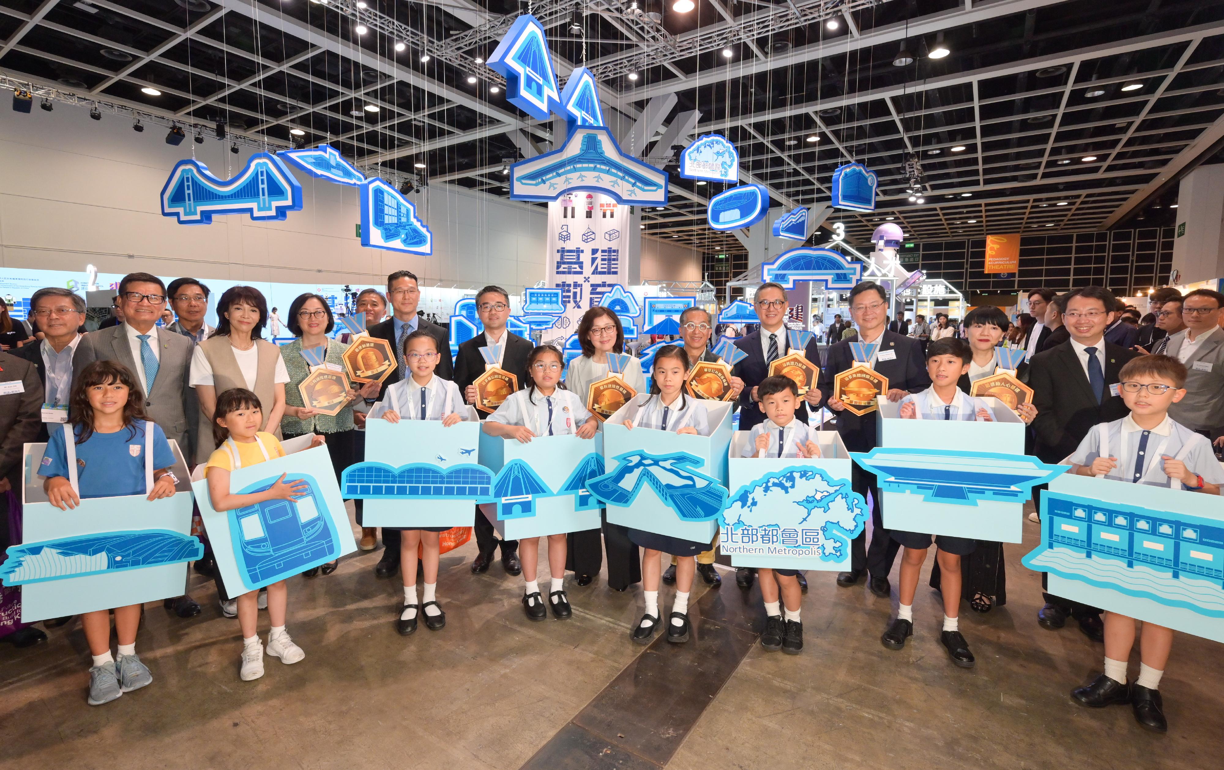 The launching ceremony of the Infrastructure x Education Exhibition and the first phase of achievement of the STEAM UP project, jointly organised by the Development Bureau and the Construction Industry Council (CIC), was held today (July 3). Photo shows the Secretary for Development, Ms Bernadette Linn (back row, sixth right); the Permanent Secretary for Development (Works), Mr Ricky Lau (back row, fourth right); the Under Secretary for Education, Dr Sze Chun-fai (back row, seventh right); the Chairman of the CIC, Professor Thomas Ho (back row, fifth right); and the Executive Director of the CIC, Mr Albert Cheng (back row, second left), with the other guests and students in front of the Hong Kong's first 3-dimensional Infrastructure Map.