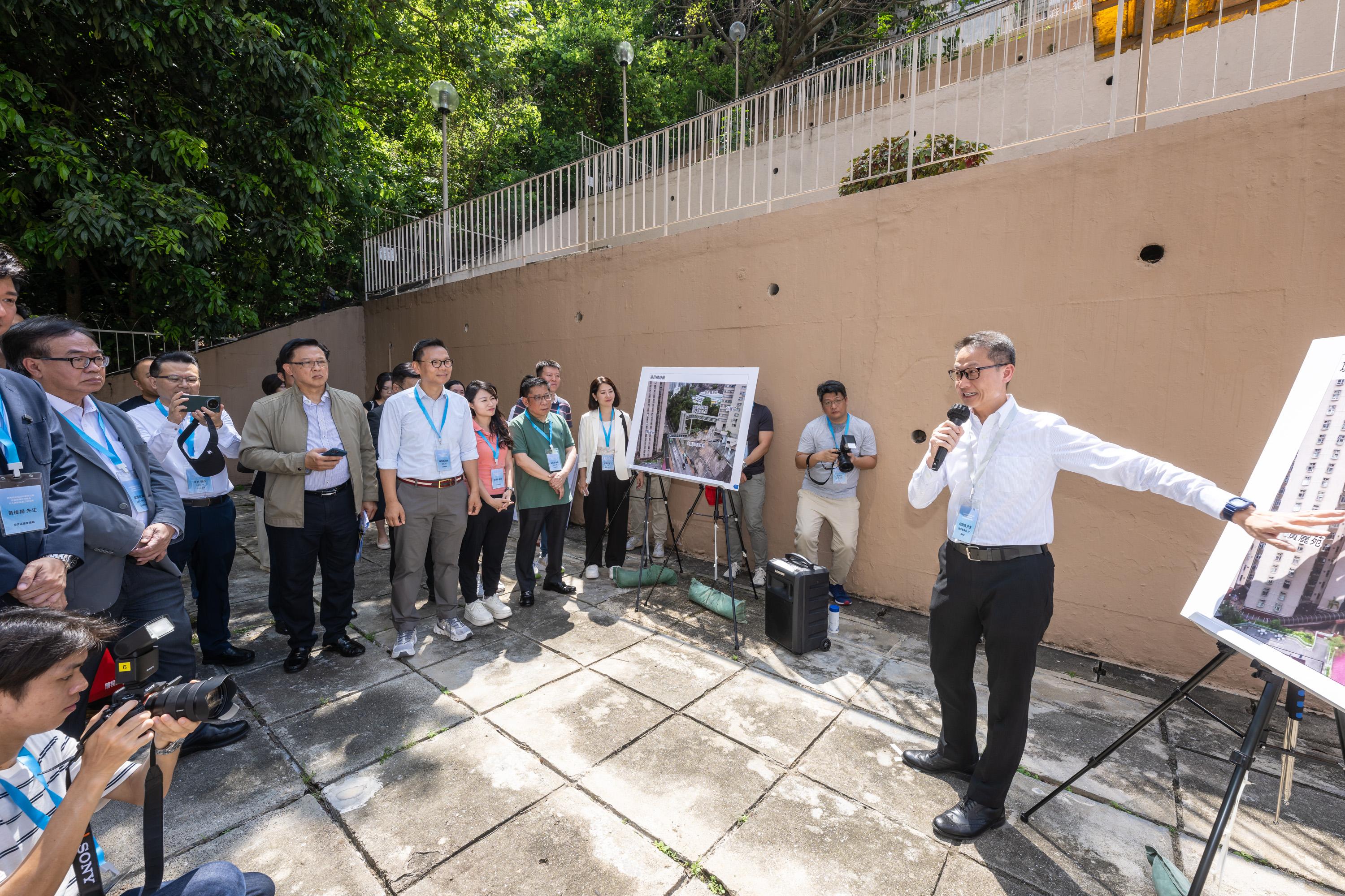 The Legislative Council (LegCo) Members and Kwai Tsing District Council members inspect the proposed lift and pedestrian walkway system between Lai King Hill Road and Lai Cho Road today (July 4) to follow up on the issue of enhancing barrier-free facilities in Kwai Tsing. Photo shows LegCo Members receiving a briefing by a representative of the Highways Department on the plan of the proposed lift and pedestrian walkway system.
