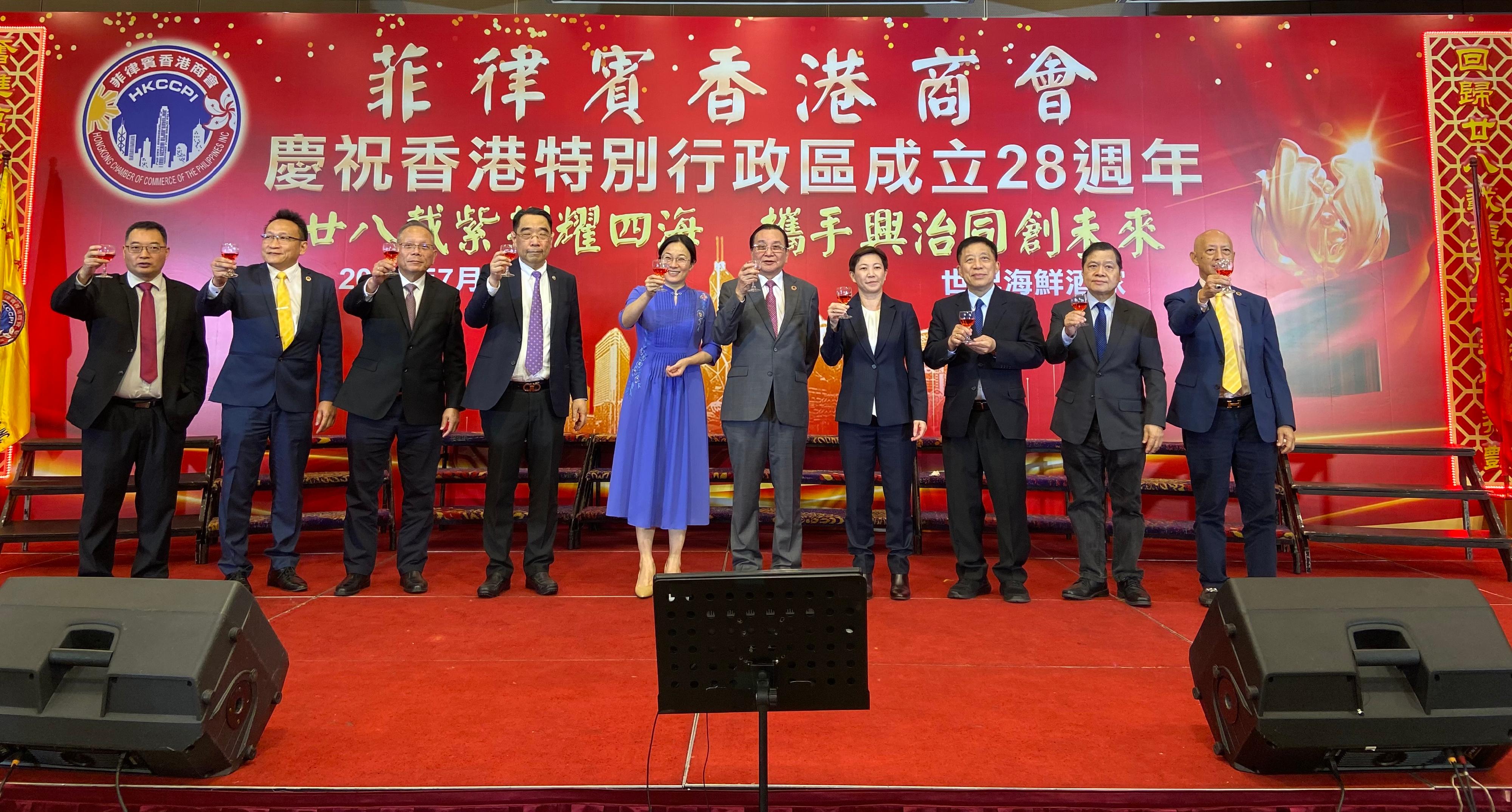The Director-General of the Hong Kong Economic and Trade Office in Jakarta, Miss Libera Cheng, attended a dinner organised by the Hongkong Chamber of Commerce of the Philippines Inc in Manila, the Philippines, today (July 5) to celebrate the 28th anniversary of the establishment of the Hong Kong Special Administrative Region. Photo shows shows Miss Cheng (fourth right); the Minister Counsellor of the Chinese Embassy in the Philippines, Ms Wang Yulei (fifth left); the President of the Hongkong Chamber of Commerce of the Philippines Inc, Mr Parros Poon (fifth right), proposing a toast with other officiating guests at the dinner.