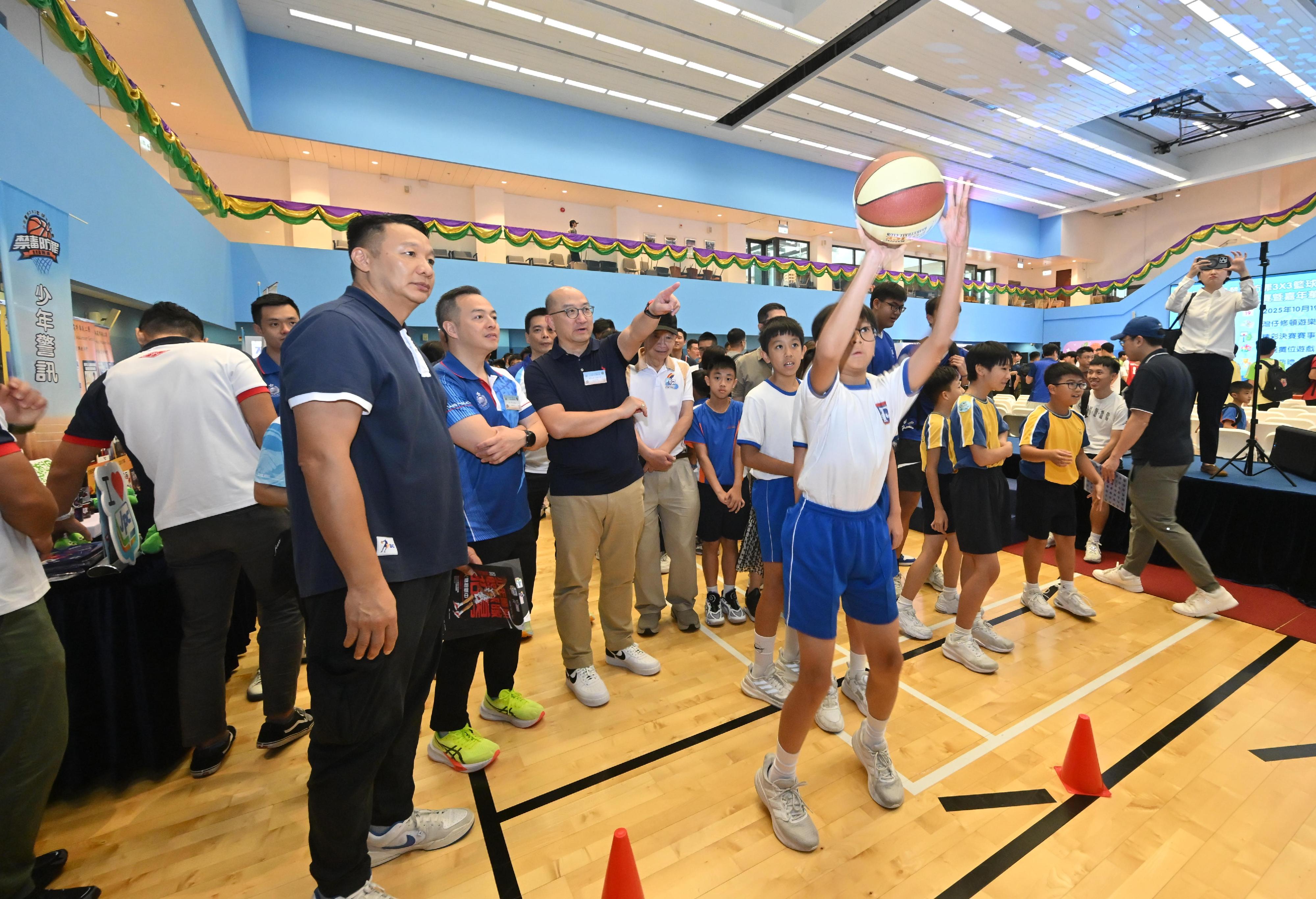 The Hong Kong Police Force today (July 6) held the kick-off ceremony for the Junior Police Call (JPC) Anti-Narcotics and Fight Crime 3x3 Basketball Training Programme 2025. Photo shows the Commissioner of Police, Mr Chow Yat-ming (second left) and the Executive Director, Corporate Affairs of The Hong Kong Jockey Club, Mr Raymond Tam (third left) visiting a game booth. 