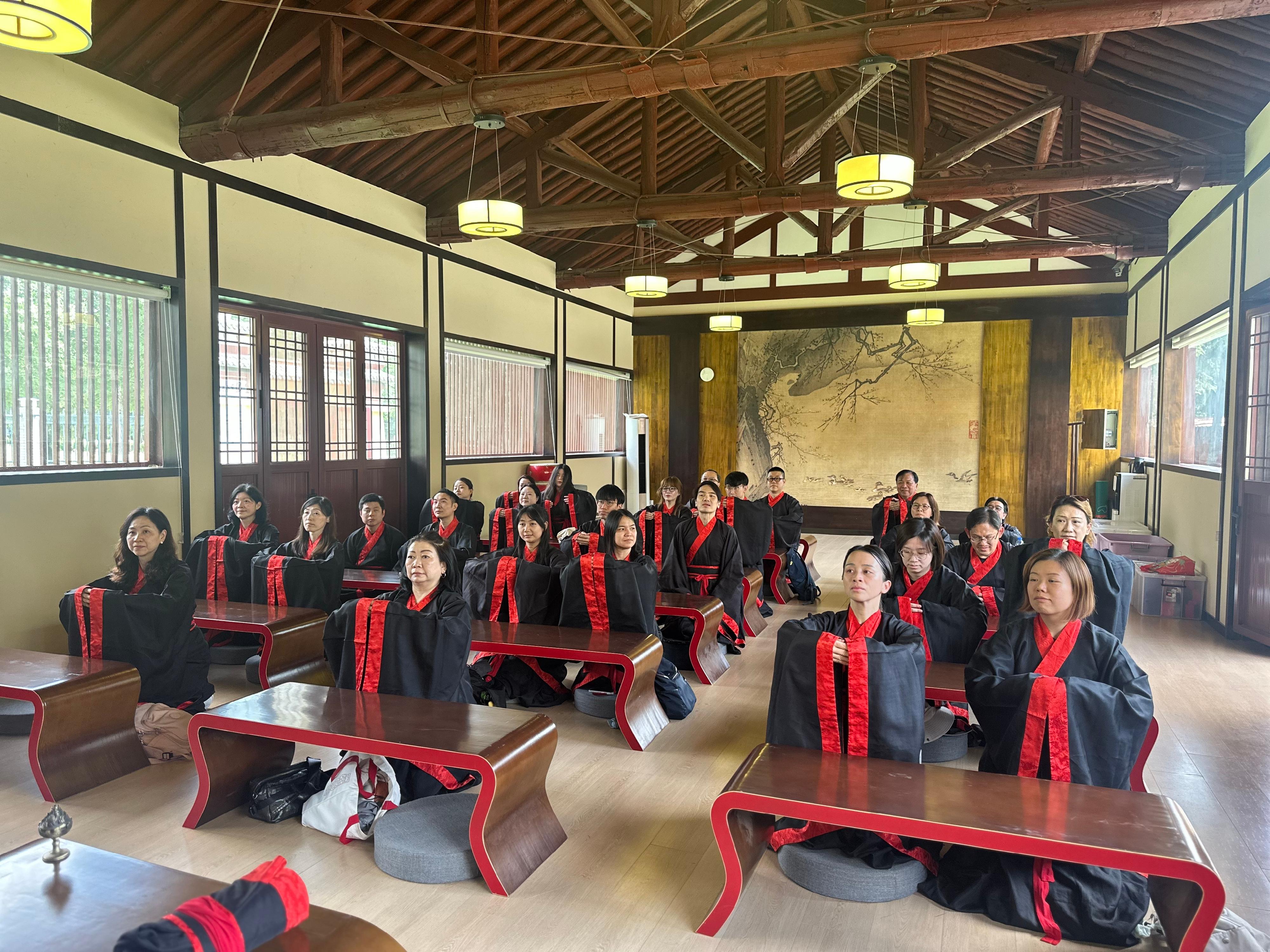 The teacher study tour to Shaanxi on the ancient civilisation of the Qin and Han dynasties, co-organised by the Chinese Culture Promotion Office of the Leisure and Cultural Services Department and the Education Bureau, led 23 secondary school Chinese history teachers to visit various major museums and cultural institutions in Xi'an from June 27 to July 1. Photo shows teachers experiencing Han etiquette through wearing traditional Han clothing (Hanfu), kneeling, sitting, and bowing. 
