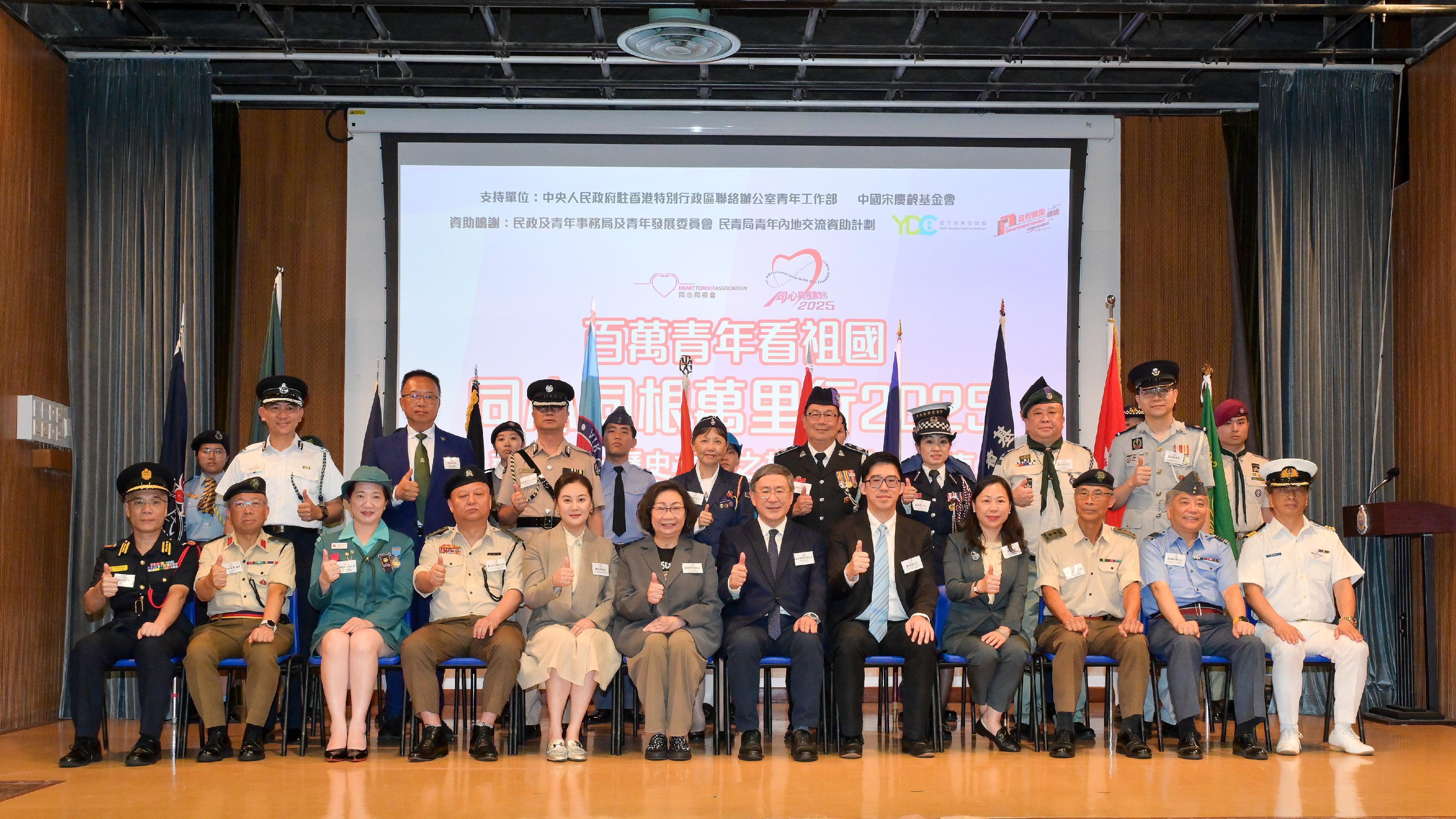 政務司副司長卓永興今日（七月十一日）出席同心同根萬里行2025授旗禮。圖示（前排左五起）同心同根萬里行2025榮譽團長顧笑洋、同心同根會創會會長、同心同根萬里行2025活動召集人暨團長梁唐青儀、卓永興、中央人民政府駐香港特別行政區聯絡辦公室青年工作部副處長盧頌揚與主禮嘉賓團及團隊長官台上合照。