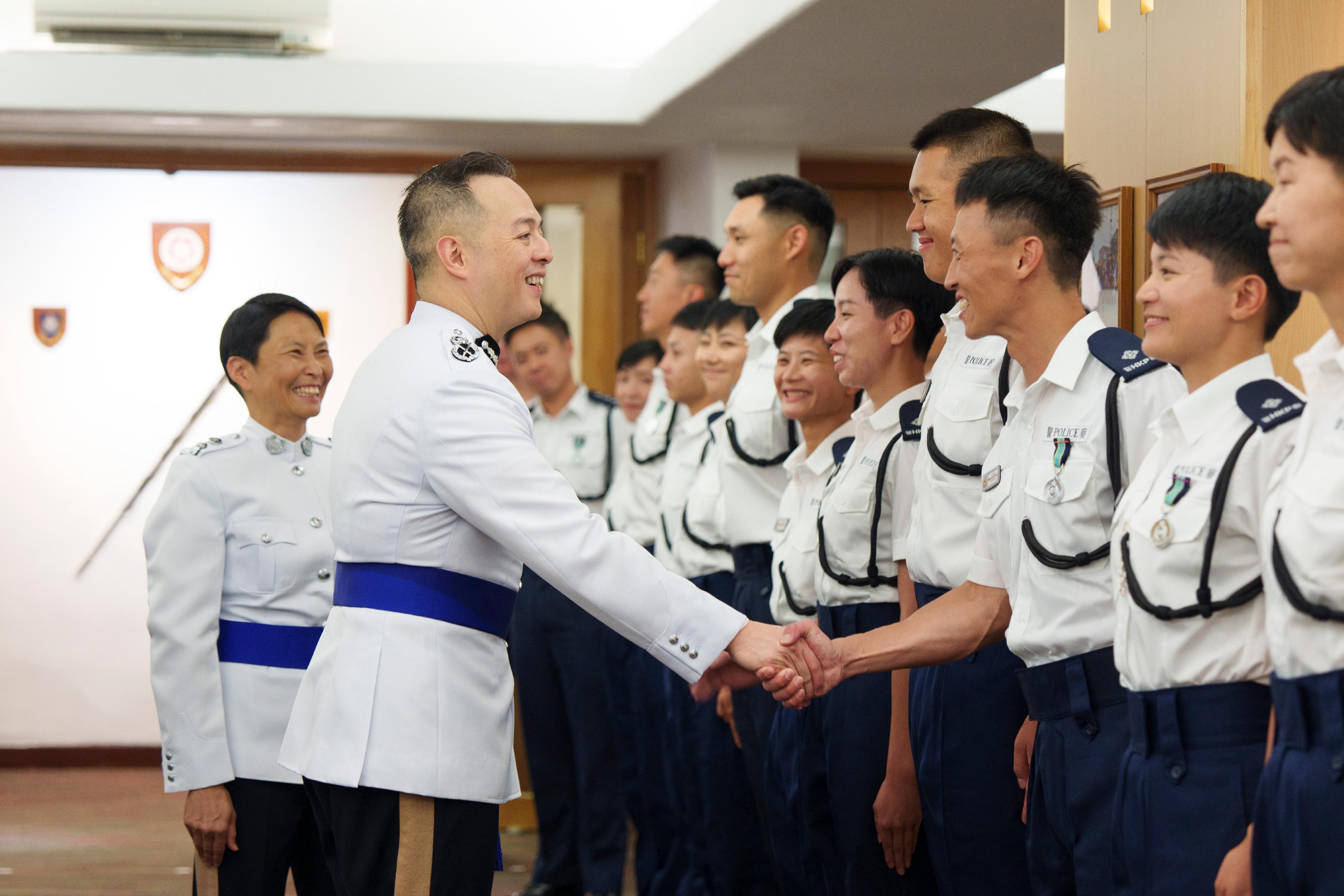 The Commissioner of Police, Mr Chow Yat-ming (second left), congratulates the probationary inspectors after the passing-out parade held at the Hong Kong Police College today (July 12).