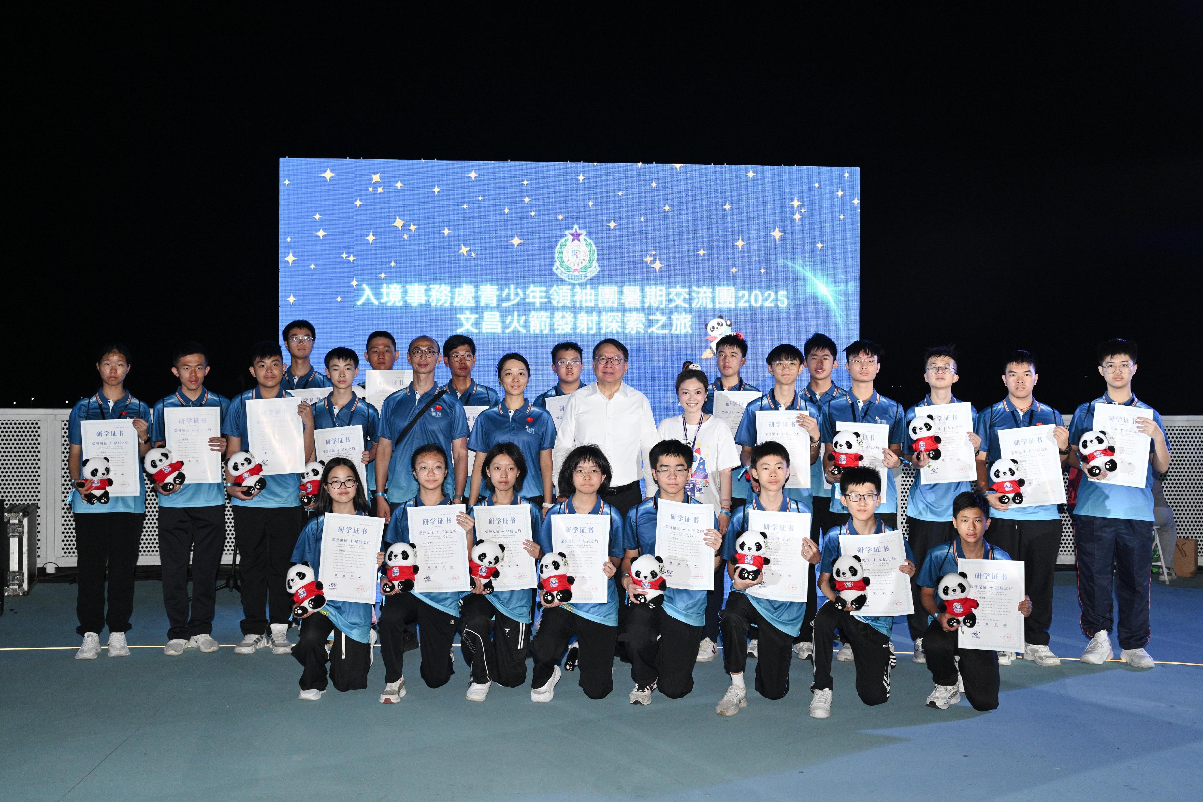 政務司司長陳國基今日（七月十五日）在海南省文昌瑤光火箭發射觀禮平台參與「共創明『Teen』計劃」──海南航天太空科研學習團。圖示陳國基（第二排右七）和「共創明『Teen』計劃」團體活動諮詢委員會主席、學習團團長廖玲玲（第二排右六）與入境事務處青少年領袖團團員合照。