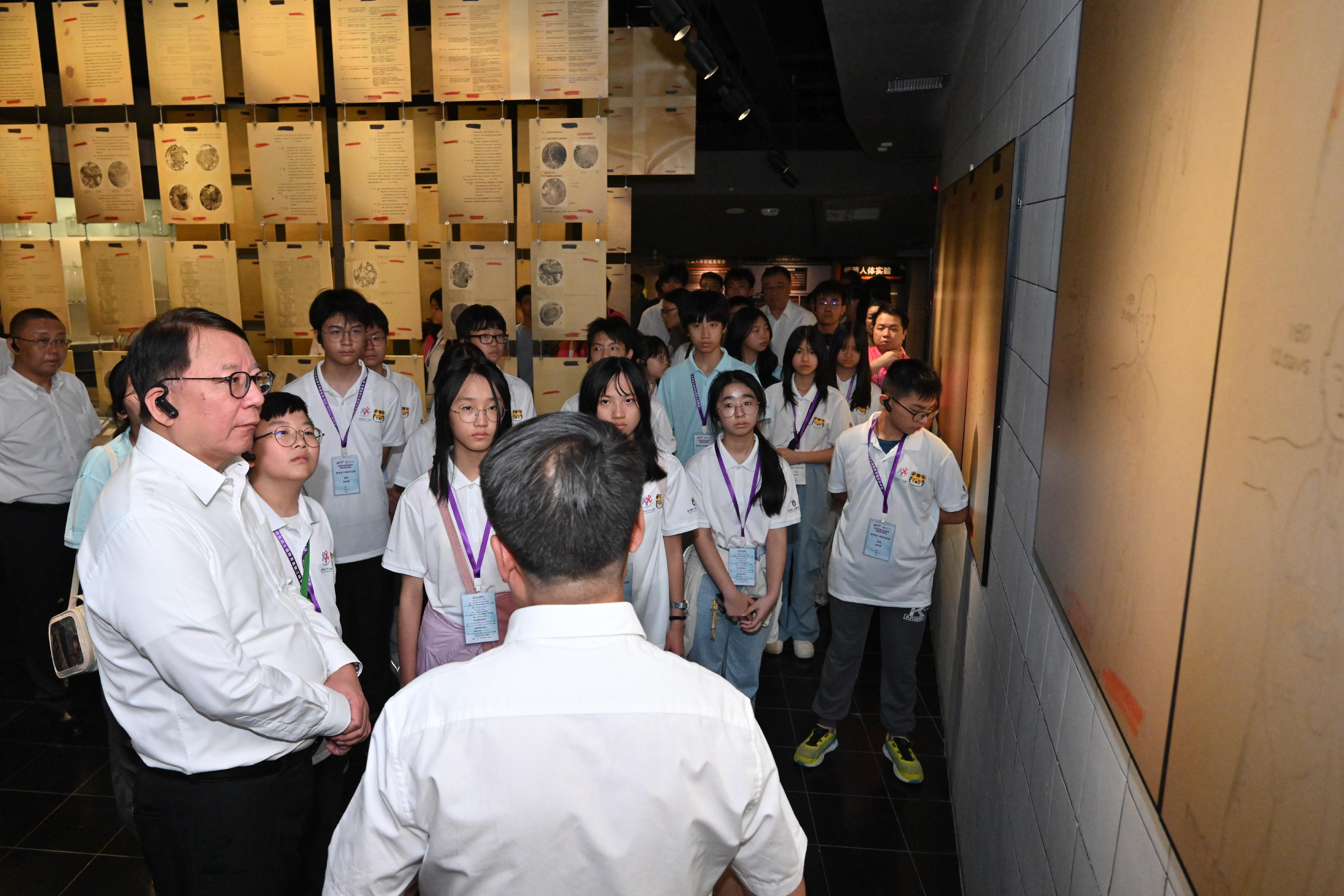 The Chief Secretary for Administration, Mr Chan Kwok-ki, continued his visit to Heilongjiang Province today (July 16). Photo shows Mr Chan (first left) and members of the Hong Kong Patriotic Education Heilongjiang Study Tour under the Strive and Rise Programme visiting the Exhibition Hall of Evidences of Crime Committed by Unit 731 of the Japanese Imperial Army, and being briefed by a staff member.