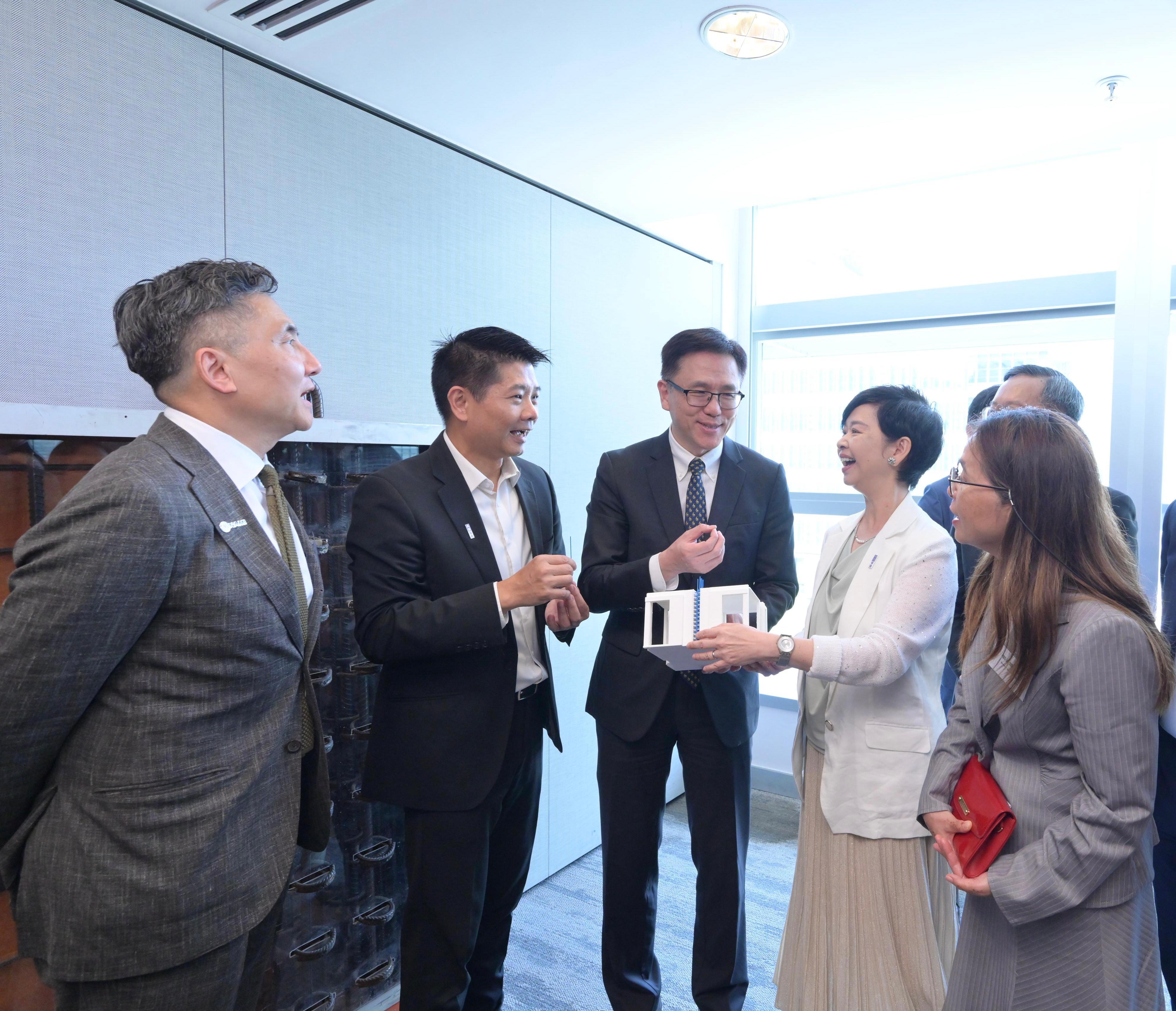 房屋局與納米及先進材料研發院今日（七月十七日）簽署合作備忘錄，建立策略夥伴合作關係，旨在整合雙方優勢，構建從研發到市場應用的完整創新生態鏈，以新思維、新科技「築可能，構未來」。圖示（左起）納米及先進材料研發院行政總裁馮振宇、房屋署助理署長（發展及採購）葉成林博士、創新科技及工業局局長孫東教授、房屋局局長何永賢及納米及先進材料研發院董事局主席鄭淑嫻教授參觀產品展示區。