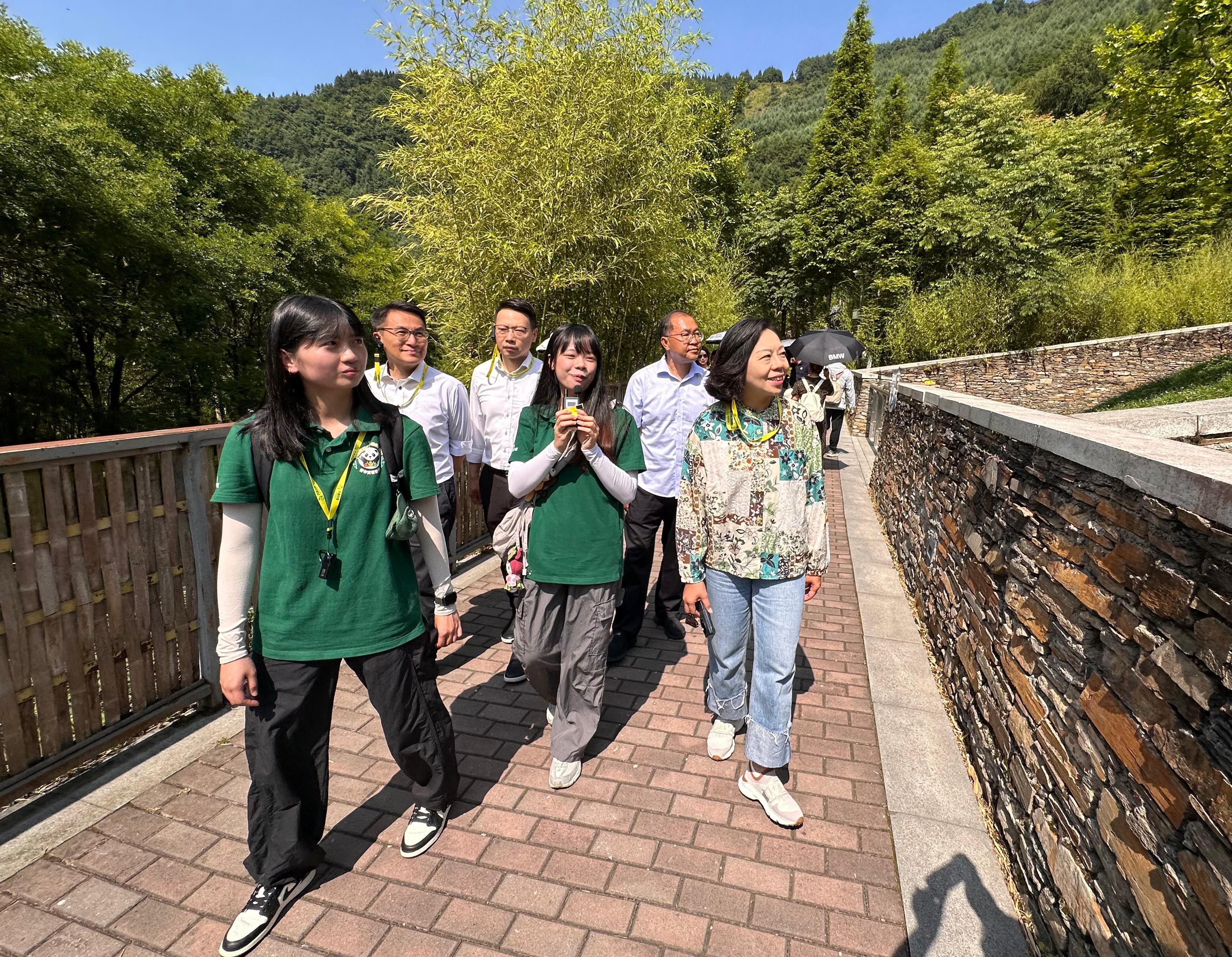 民政及青年事務局局長麥美娟今日（七月十七日）在四川展開訪問行程。圖示麥美娟（前排右一）在中國大熊貓保護研究中心神樹坪基地，聽取擔任講解員的大熊貓國家公園臥龍片區青年實習計劃香港青年實習生的簡介。

