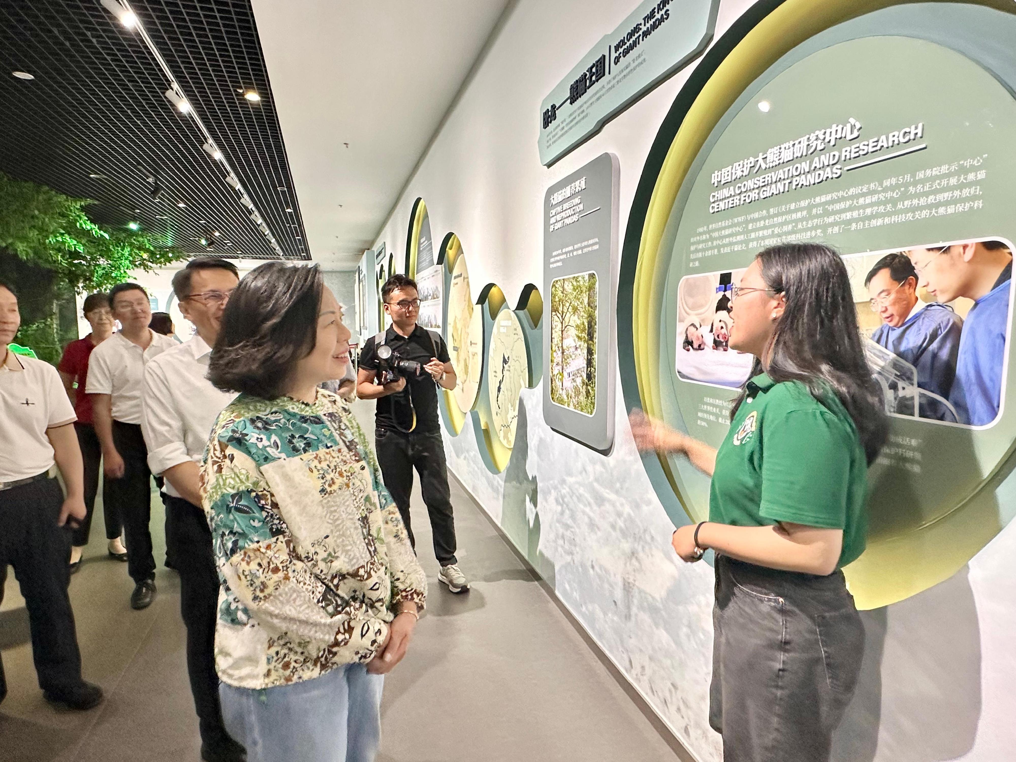 The Secretary for Home and Youth Affairs, Miss Alice Mak, began her visit to Sichuan today (July 17). Photo shows Miss Mak (front row, left) being briefed by a Hong Kong youth participating in the Youth Internship Programme at Wolong Region of Giant Panda National Park on nature conservation and the caring and rearing of giant pandas in the Wolong Natural Museum of the Giant Panda National Park.