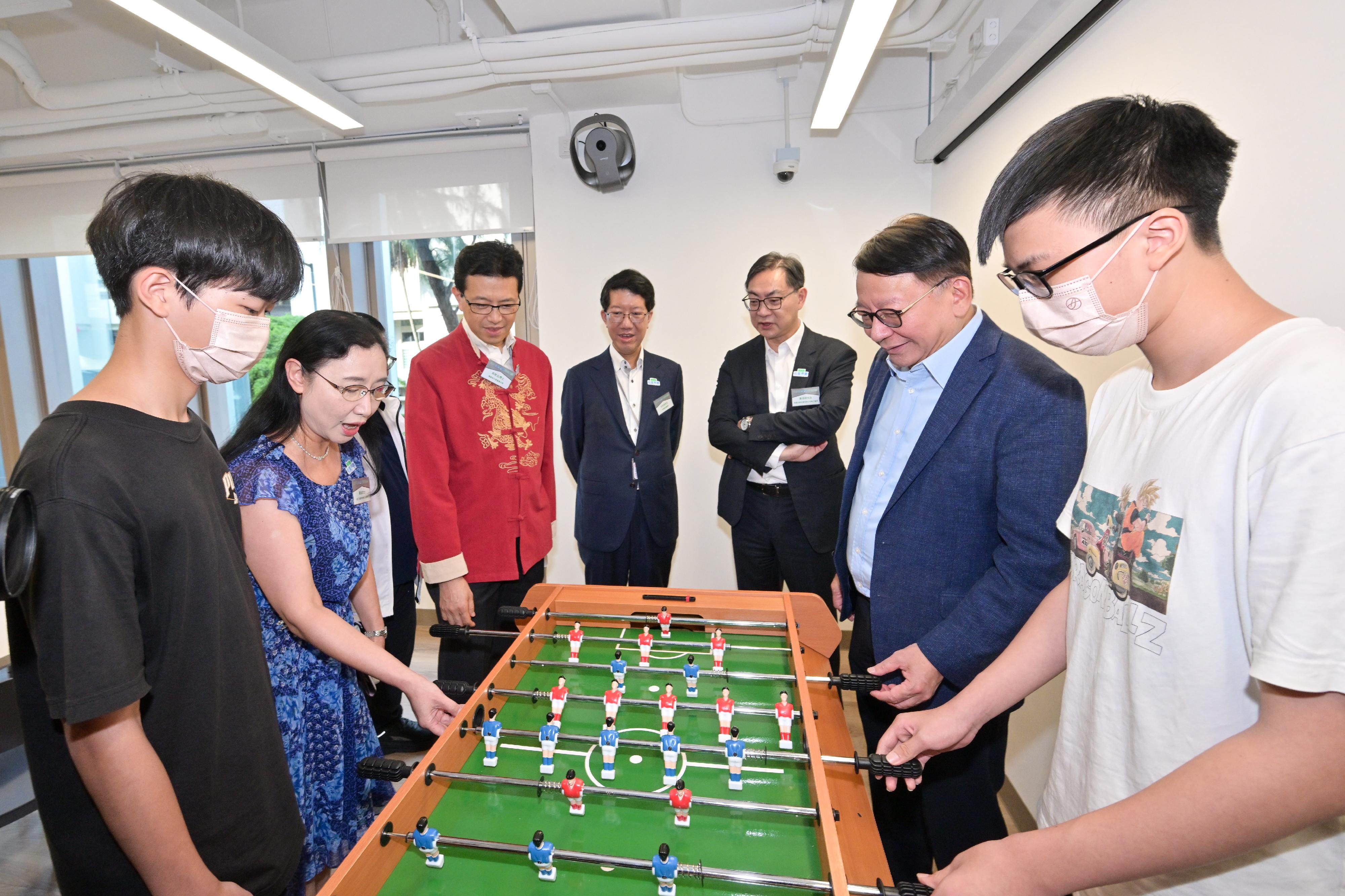 政務司司長陳國基今日（七月十七日）主持太子社區客廳開幕典禮。勞工及福利局局長孫玉菡、恒基兆業地產有限公司執行董事黃浩明、勞工及福利局常任秘書長劉焱、社會福利署署長杜永恒和樂群社會服務處執行委員會主席吳秋北博士亦一同主禮。圖示陳國基（右二）和劉焱（左二）在多功能活動區與受惠人士玩足球機，並與他們交流。
