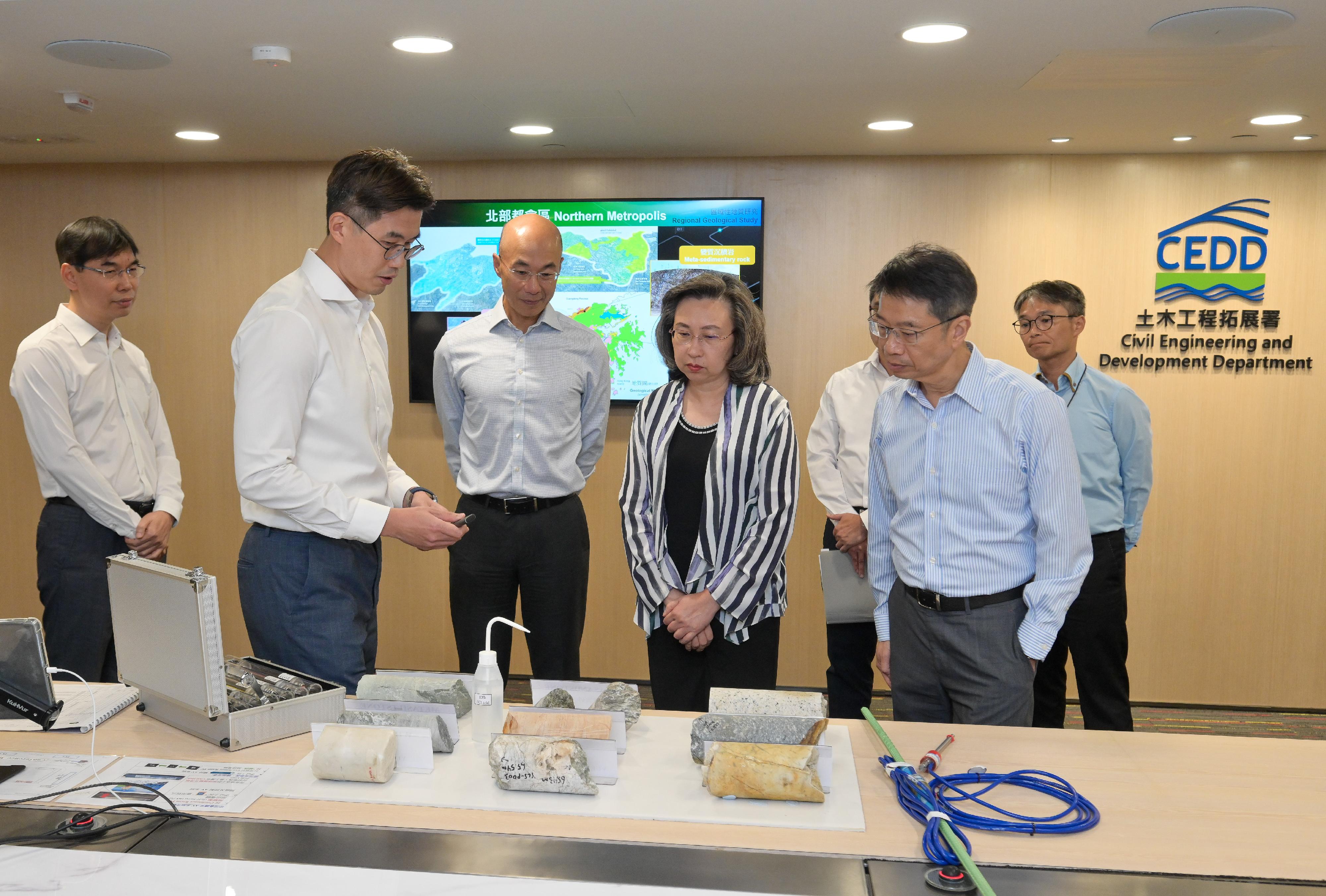 The Secretary for the Civil Service, Mrs Ingrid Yeung, visited the Civil Engineering and Development Department this afternoon (July 18) to learn about the department's latest progress in optimising operational efficiency and services through the application of technology, as well as its work in landslip prevention and mitigation and slope safety. Photo shows Mrs Yeung (front row, second right) being briefed by staff on a ground investigation study in the Northwest New Territories initiated by the Geotechnical Engineering Office, enhancing the speed and efficiency to assist in promoting the development of the Northern Metropolis.  Looking on are the Permanent Secretary for the Civil Service, Mr Clement Leung (front row, first right), and the Director of Civil Engineering and Development, Mr Michael Fong (front row, centre).