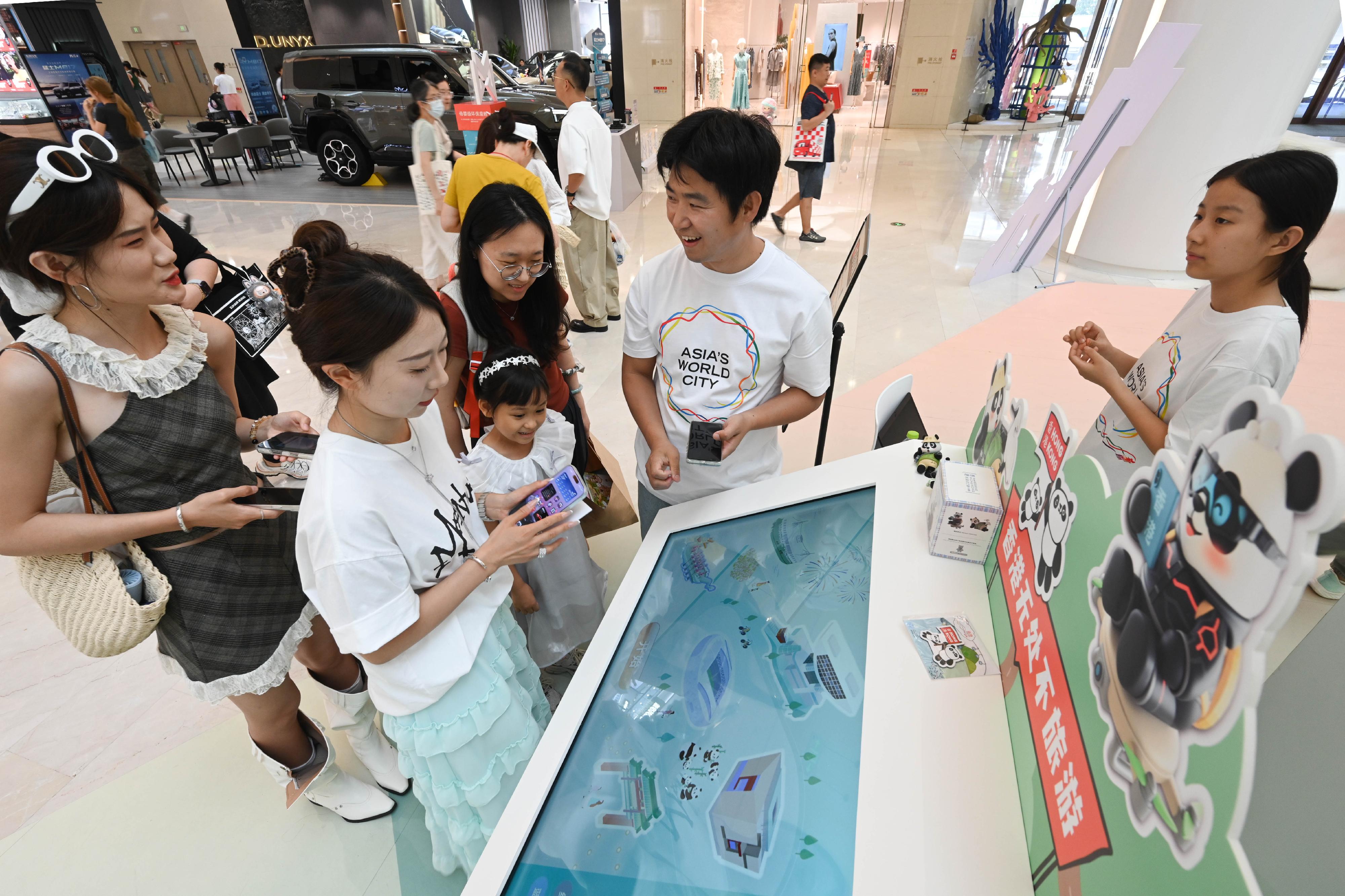 「香港─沉浸式之旅」巡迴展覽今日（七月十八日）在青島展開，利用互動藝術科技，展示香港的多元面貌和最新發展。展覽旨在讓青島以至山東省民眾通過展覽，探索香港在旅遊、教育、營商和投資方面的獨特機遇和潛力。圖為參觀者參與以香港「無處不旅遊」為主題的互動遊戲。