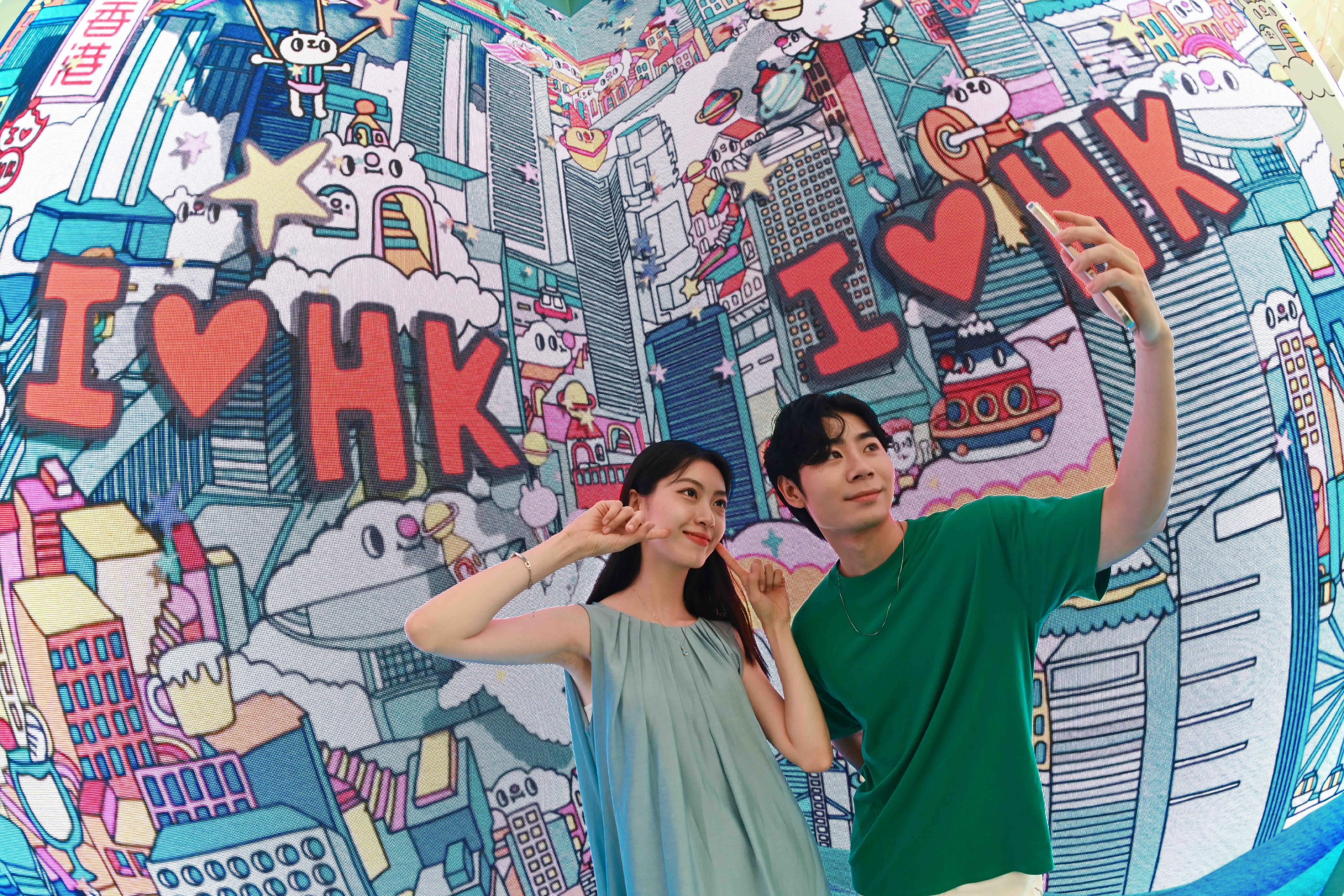 The "Immersive Hong Kong" roving exhibition, which showcases the diversity and latest developments of Hong Kong through interactive art technology, opened in Qingdao today (July 18). The exhibition invites visitors from Qingdao and the entire Shandong Province to explore the unique opportunities and potential for tourism, education, business and investment in Hong Kong. Photo shows a photo corner featuring illustration works of Hong Kong artist Messy Desk (Jane Lee) at the exhibition.