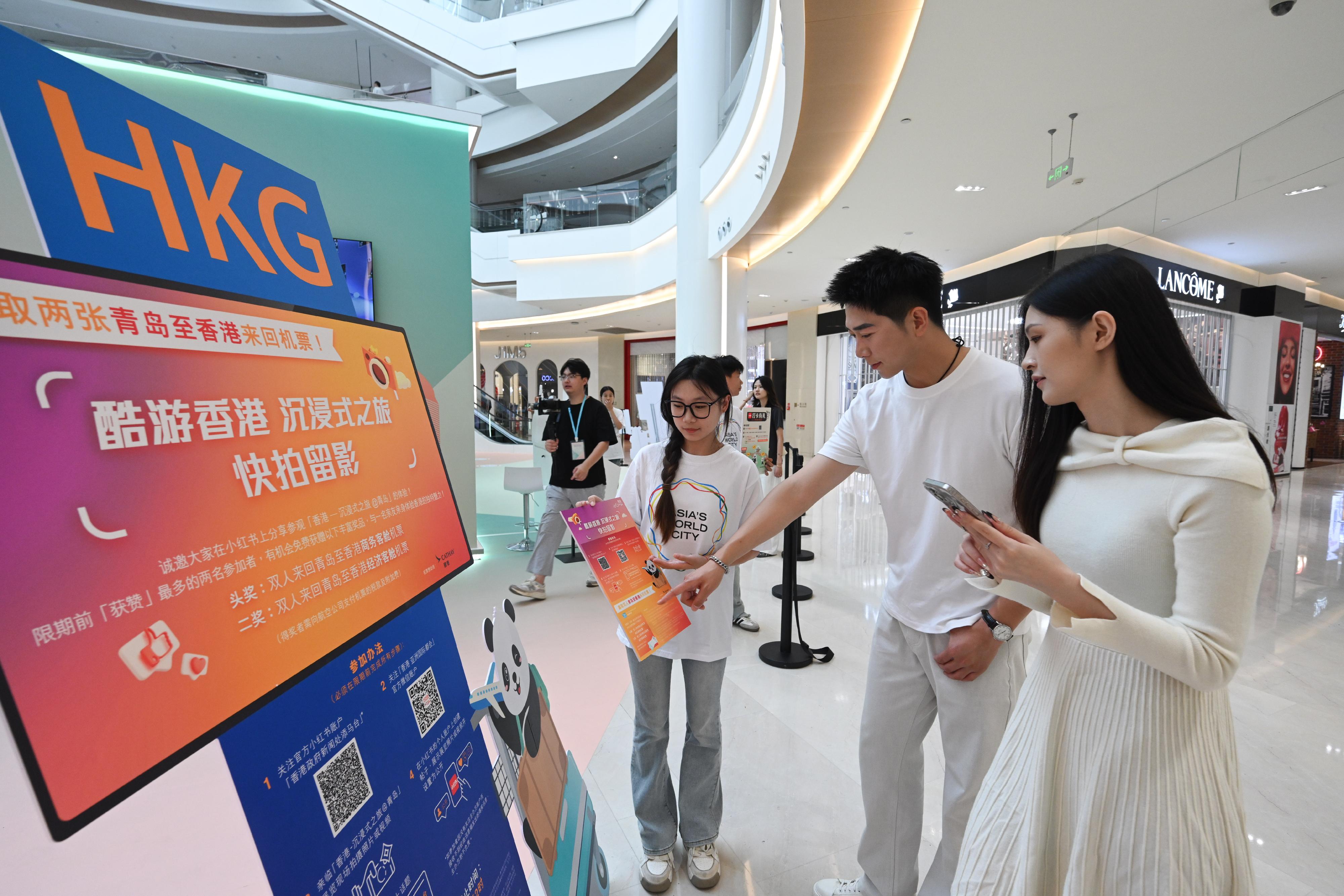 The "Immersive Hong Kong" roving exhibition, which showcases the diversity and latest developments of Hong Kong through interactive art technology, opened in Qingdao today (July 18). The exhibition invites visitors from Qingdao and the entire Shandong Province to explore the unique opportunities and potential for tourism, education, business and investment in Hong Kong. An interactive game, "Snap a cool shot @Immersive Hong Kong", is taking place at the exhibition, with round-trip air tickets sponsored by Cathay Pacific as prizes. Photo shows visitors learning about the information regarding the game.
