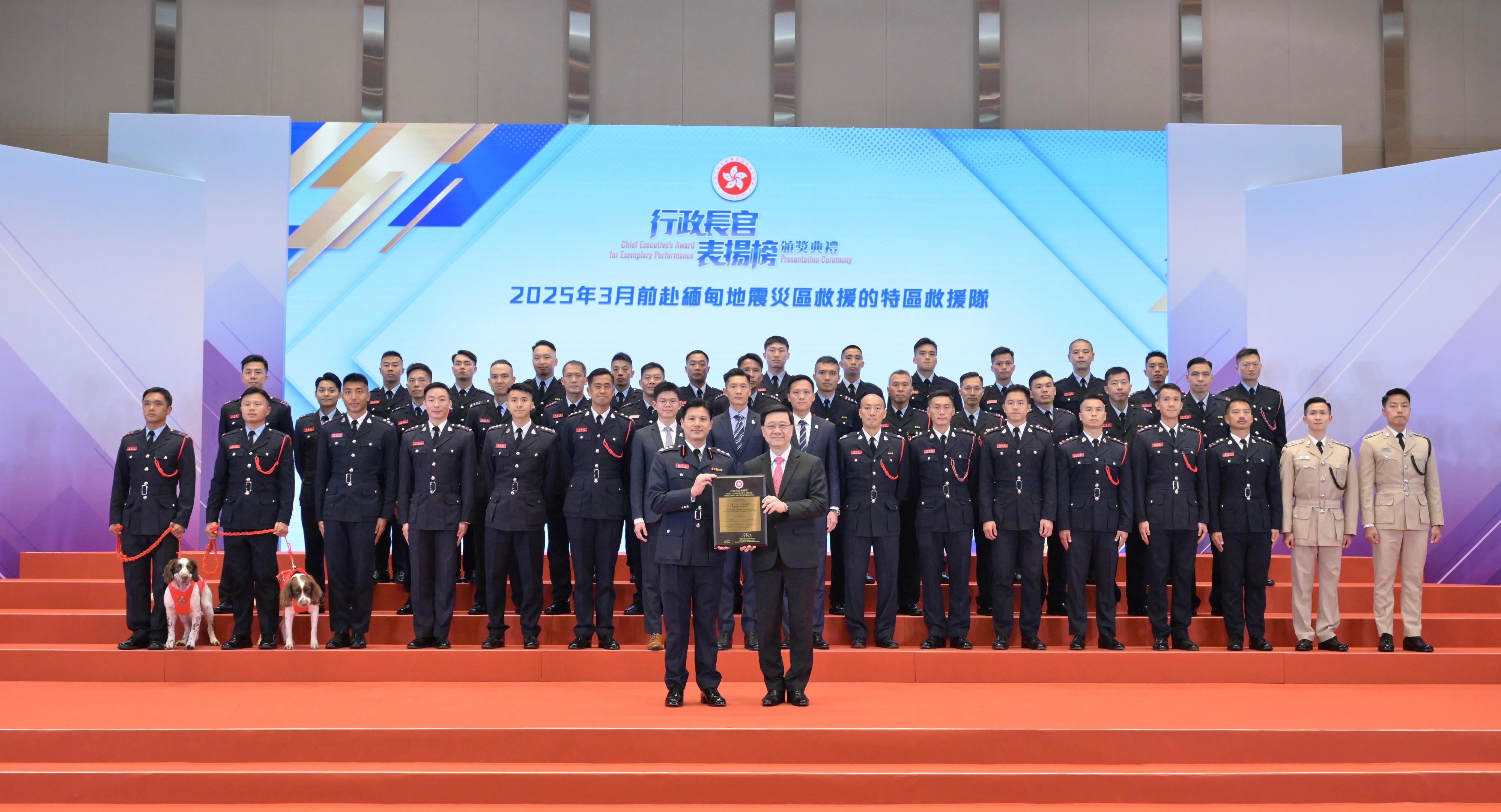 The Chief Executive, Mr John Lee, presented award certificates to the Hong Kong Special Administrative Region (HKSAR) Search and Rescue Team to quake-stricken areas in Myanmar in March 2025 at the Chief Executive's Award for Exemplary Performance Presentation Ceremony today (July 23). Photo shows Mr Lee (front row, right) presenting an award certificate to the Commander of the HKSAR Search and Rescue team, Mr Cheu Yu-kok (front row, left).