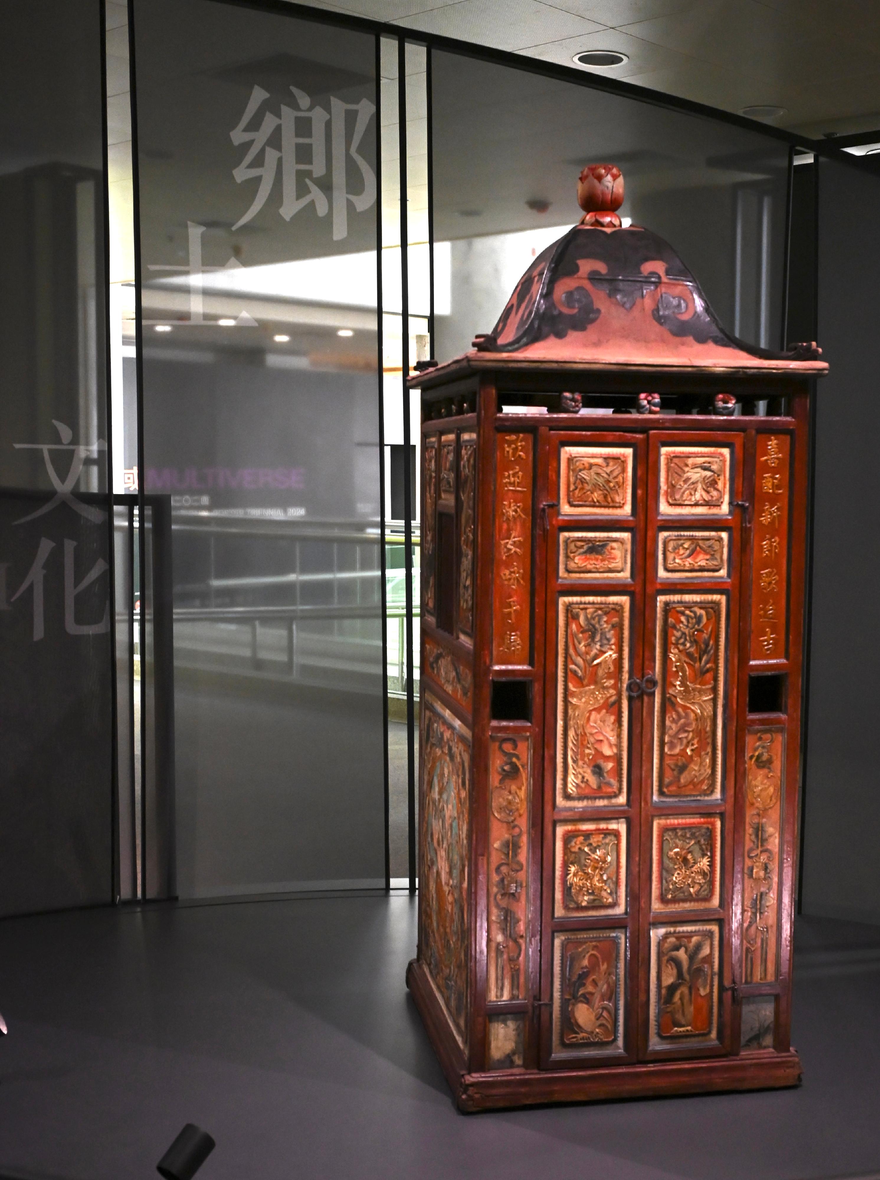 「文化薪傳—香港文化博物館二十五周年」展覽今日（七月二十三日）起至明年二月二十三日舉行。圖示已有120年歷史的客家花轎，木製轎身上直接雕刻上各種吉祥花紋和字句，寓意對婚嫁的美好祝願。
