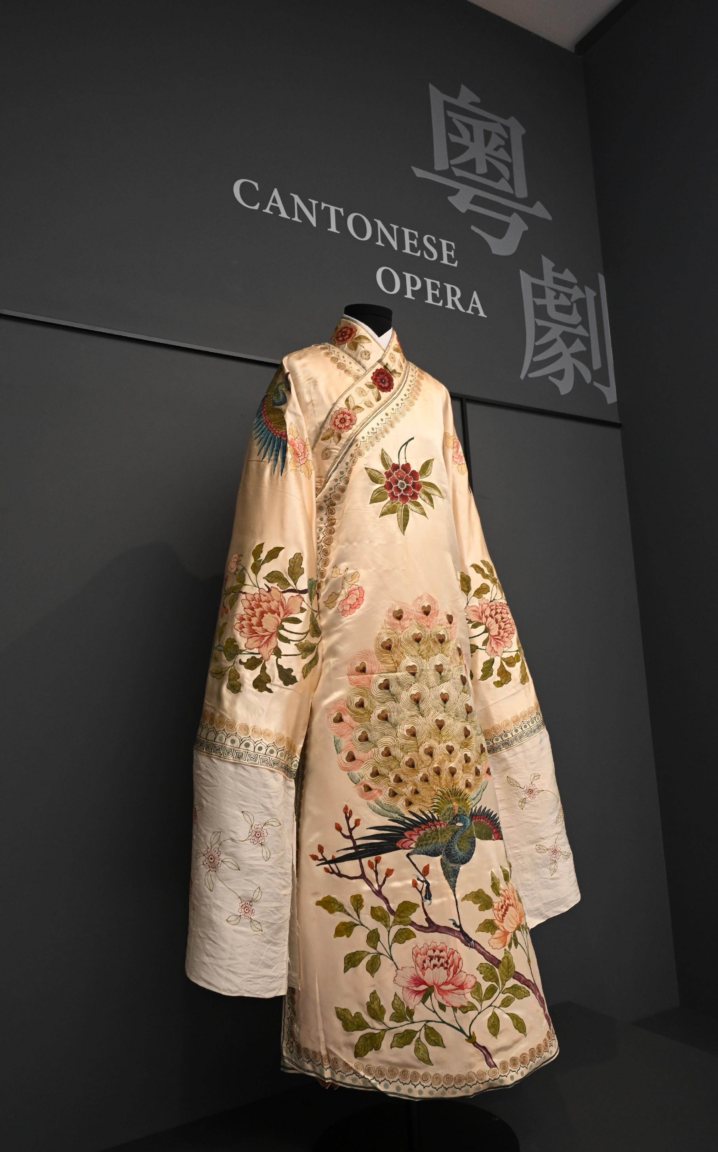 「文化薪傳—香港文化博物館二十五周年」展覽今日（七月二十三日）起至明年二月二十三日舉行。圖示手繪黃地牡丹孔雀海青戲服，是早期粵劇服飾中造工精湛的佳品。