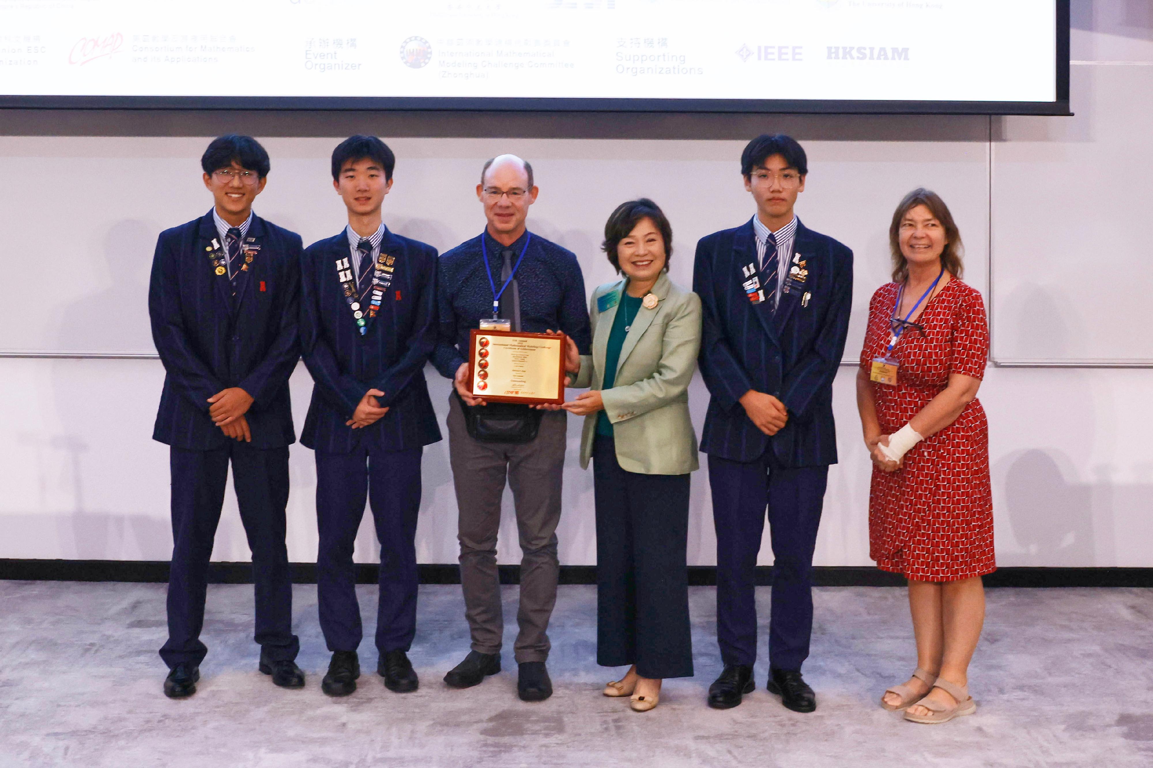 The Education Bureau co-organised the 11th Annual International Mathematical Modelling Challenge International Summit cum Award Ceremony with educational organisations and various local universities today (July 24). Photo shows the Secretary for Education, Dr Choi Yuk-lin (third right), presenting awards to the winning student team at the ceremony.