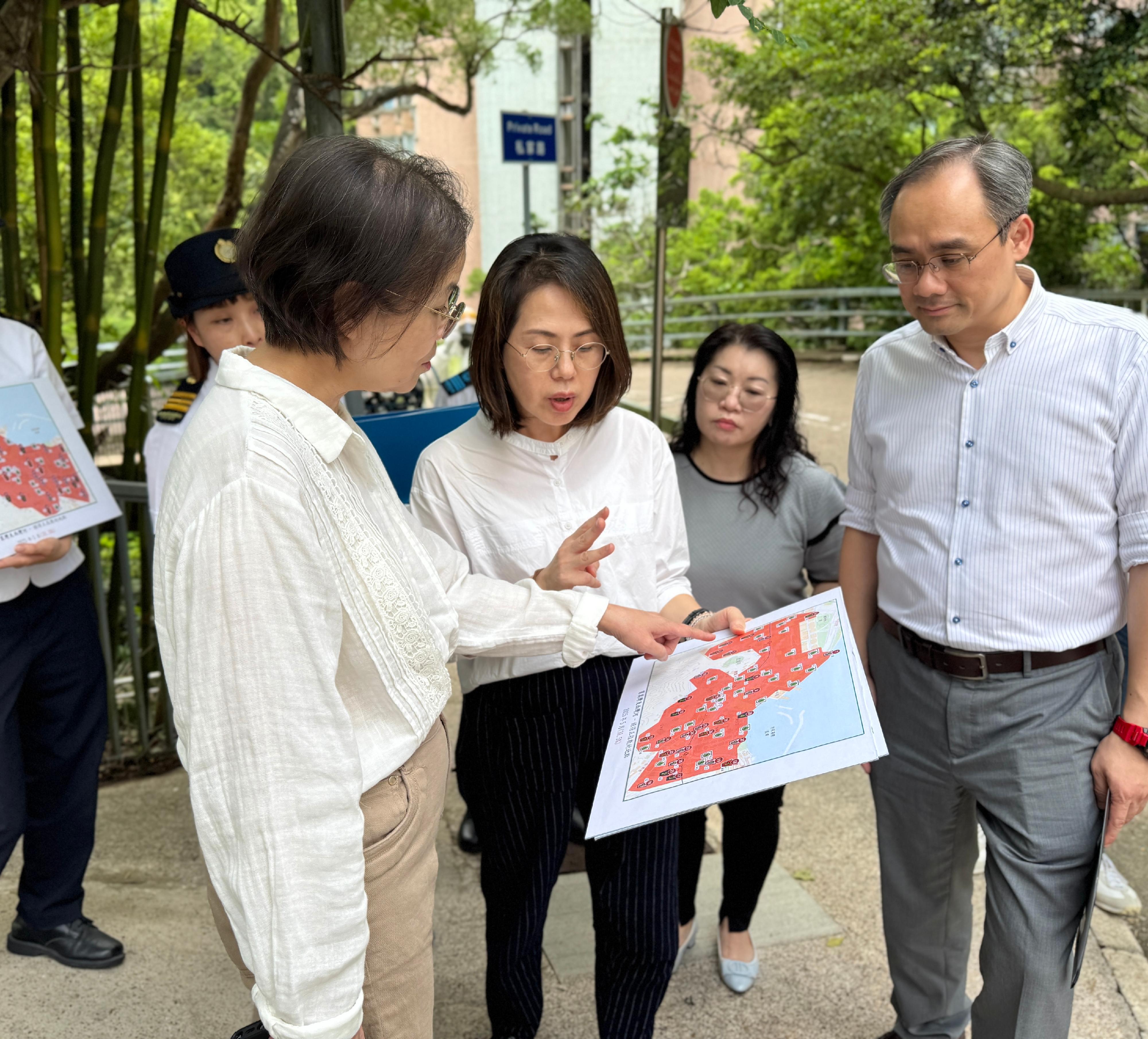 The Under Secretary for Environment and Ecology, Miss Diane Wong, and Assistant Director (Operations)  of the Food and Environmental Hygiene Department (FEHD) Mr Wan Chi-shun visited the area around Grieg Road in the Eastern District today (July 24) to inspect the enhanced chikungunya fever prevention efforts in the community. Photo shows Miss Wong (first left) and Mr Wan (first right) being briefed by FEHD staff on the gravidtrap indices in the district.