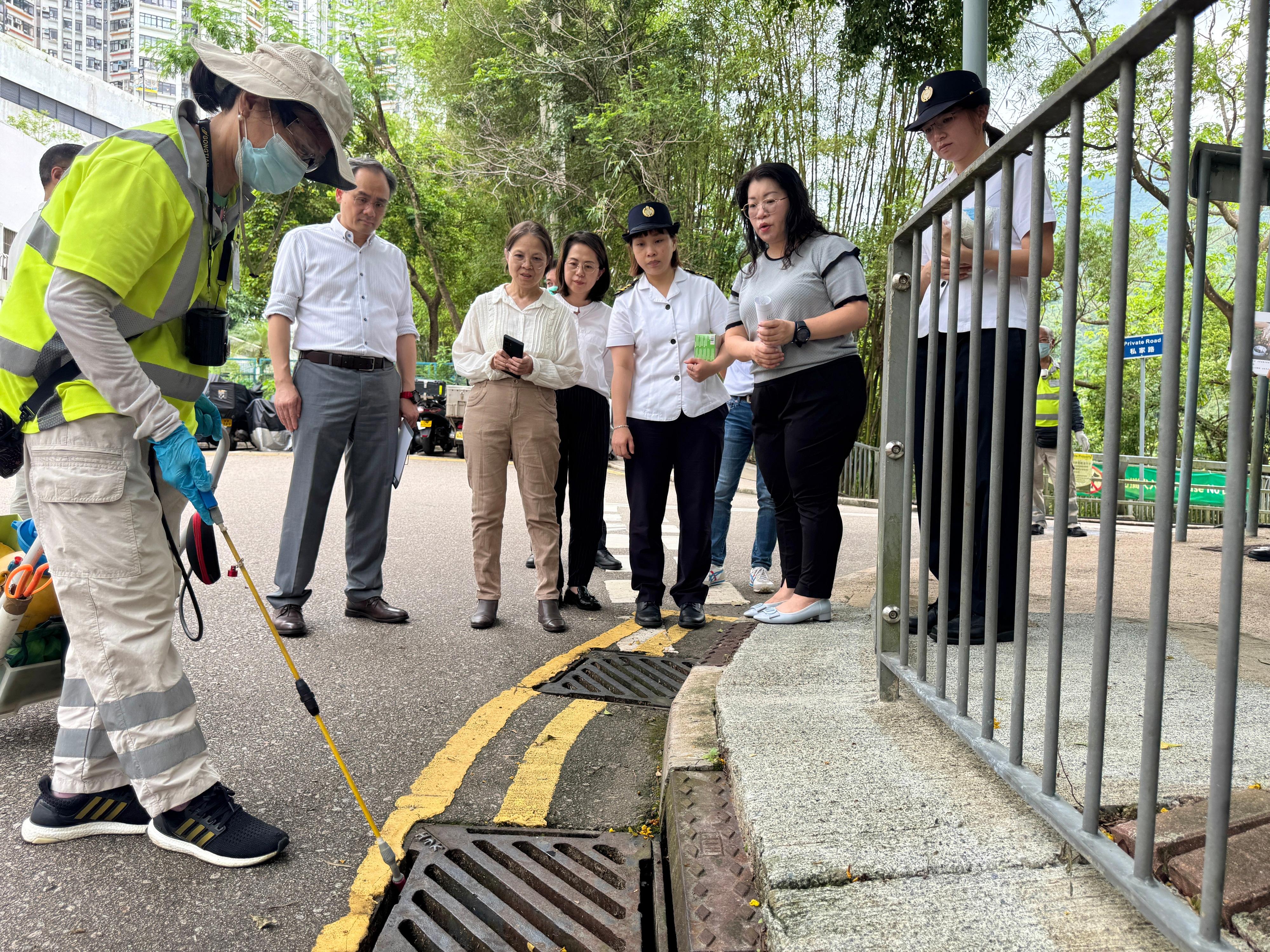 The Under Secretary for Environment and Ecology, Miss Diane Wong, and Assistant Director (Operations)  of the Food and Environmental Hygiene Department (FEHD) Mr Wan Chi-shun visited the area around Grieg Road in the Eastern District today (July 24) to inspect the enhanced chikungunya fever prevention efforts in the community. Photo shows Miss Wong (third left) and Mr Wan (second left) observing an FEHD staff member spraying larvicidal oil into drains.