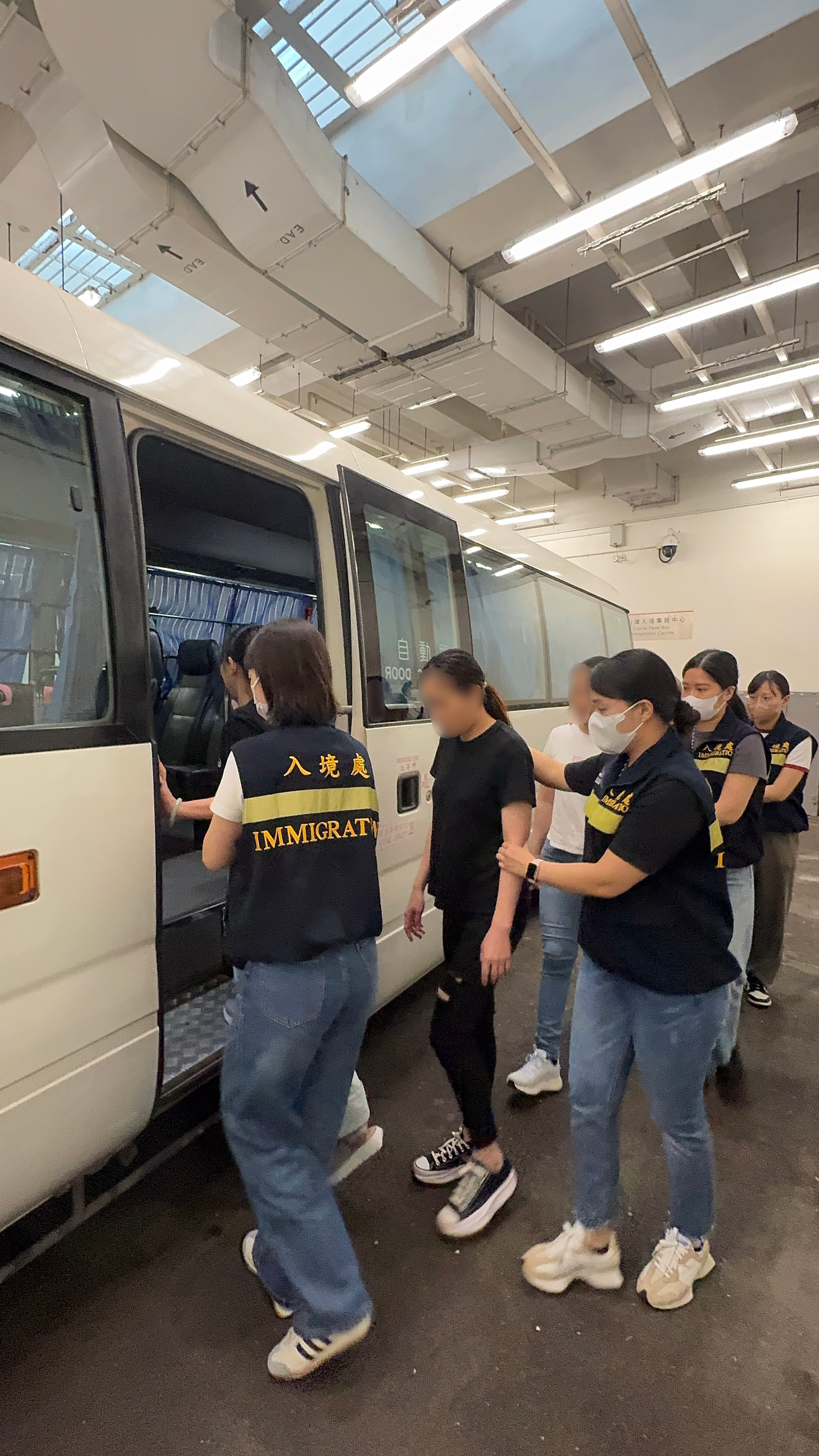 The Immigration Department (ImmD) carried out a repatriation operation today (July 25). A total of 17 Vietnamese illegal immigrants and overstayers were repatriated to Vietnam. Photo shows removees being escorted by ImmD officers to proceed from the detention place to the airport.