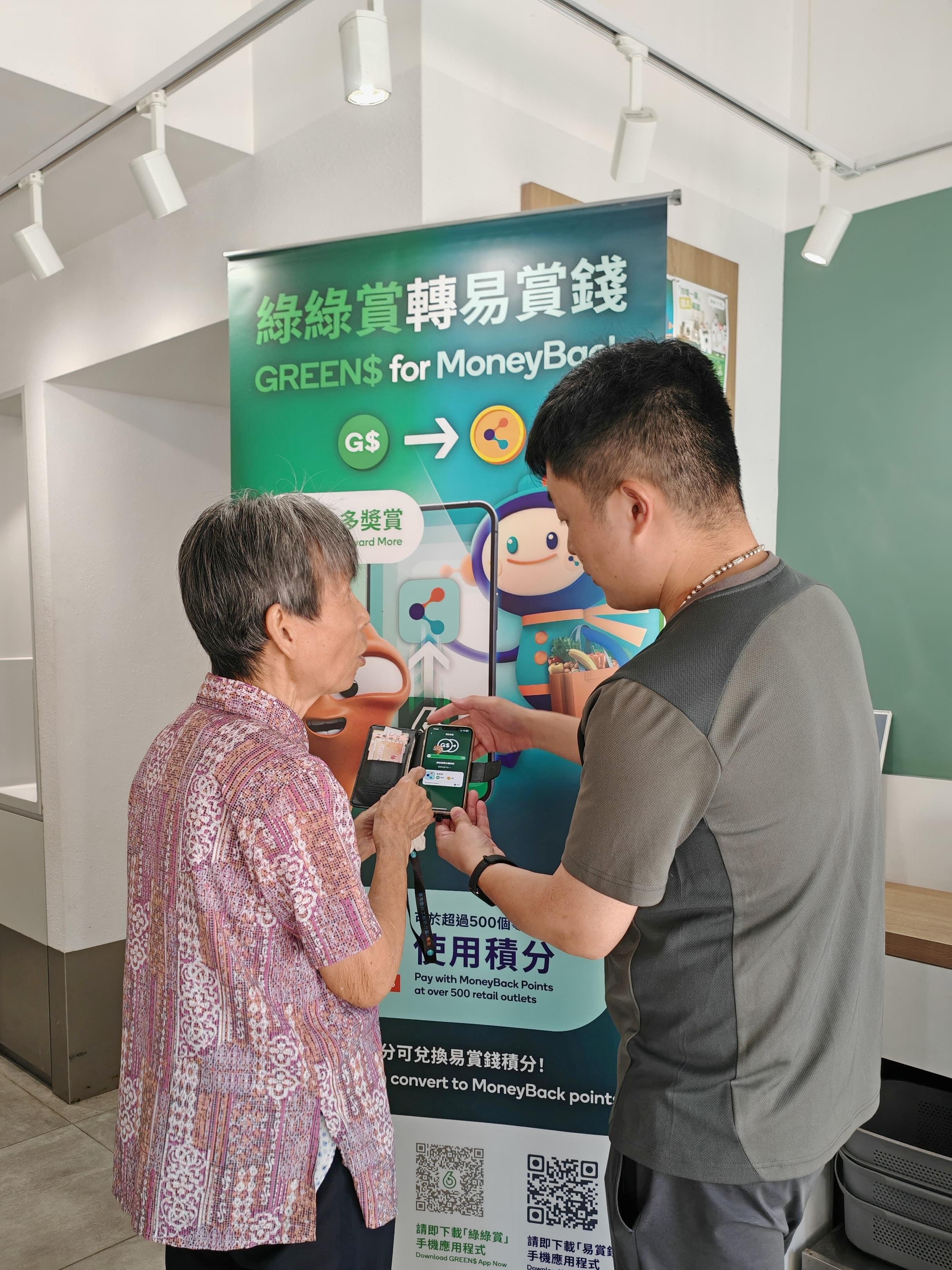 The Environmental Protection Department announced today (July 24) that the GREEN$ Electronic Participation Incentive Scheme (GREEN$ ePIS) will be fully digitised on April 1, 2026. Photo shows a staff of GREEN@COMMUNITY assisting the public in using the e-point redemption feature on GREEN$ mobile app.