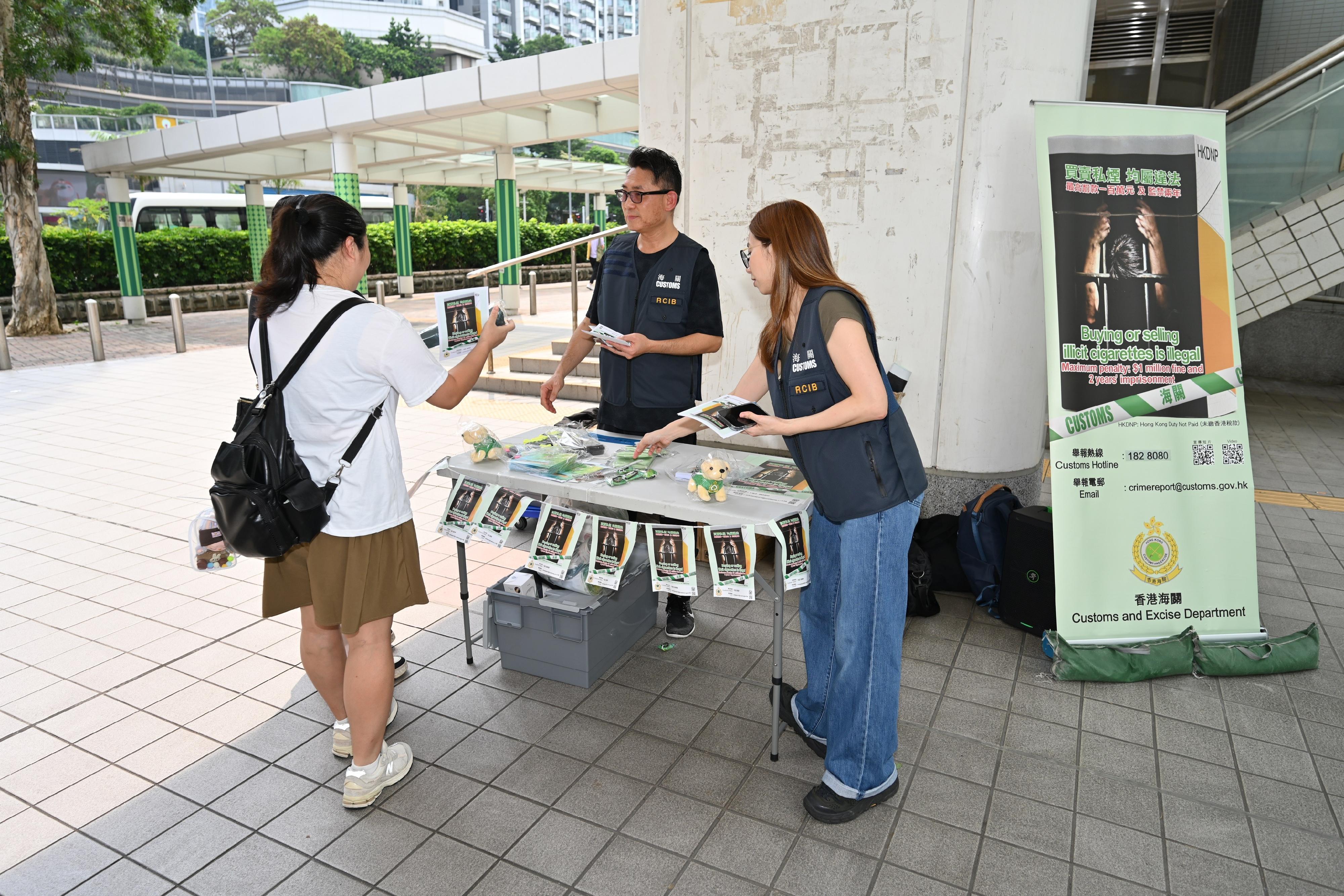 香港海關今日（七月二十八日）與立法會議員梁文廣、深水埗區區議員、衞生署控煙酒辦公室及房屋署在深水埗富昌邨進行聯合反私煙宣傳活動。圖示海關人員向居民宣傳反私煙信息。