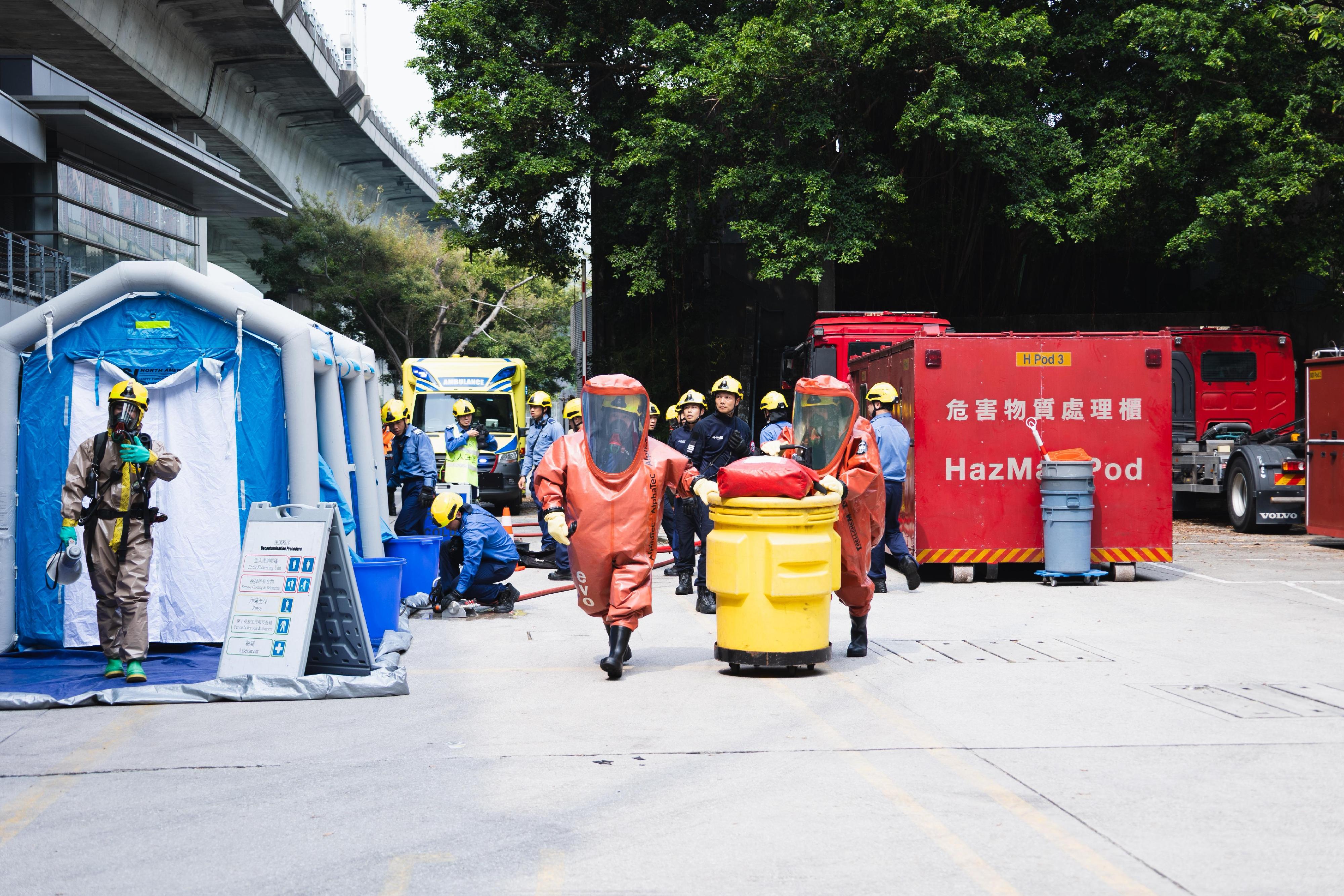 Hong Kong Customs, the Immigration Department and the Fire Services Department (FSD) conducted a joint counter-terrorism intelligence handling and hazardous material incident exercise codenamed "TREADING SEA" this afternoon (July 28) at the Tsing Yi Cargo Examination Compound. Photo shows FSD officers from the Hazardous Materials Team wearing chemical protection suits to handle hazardous material at the scene.