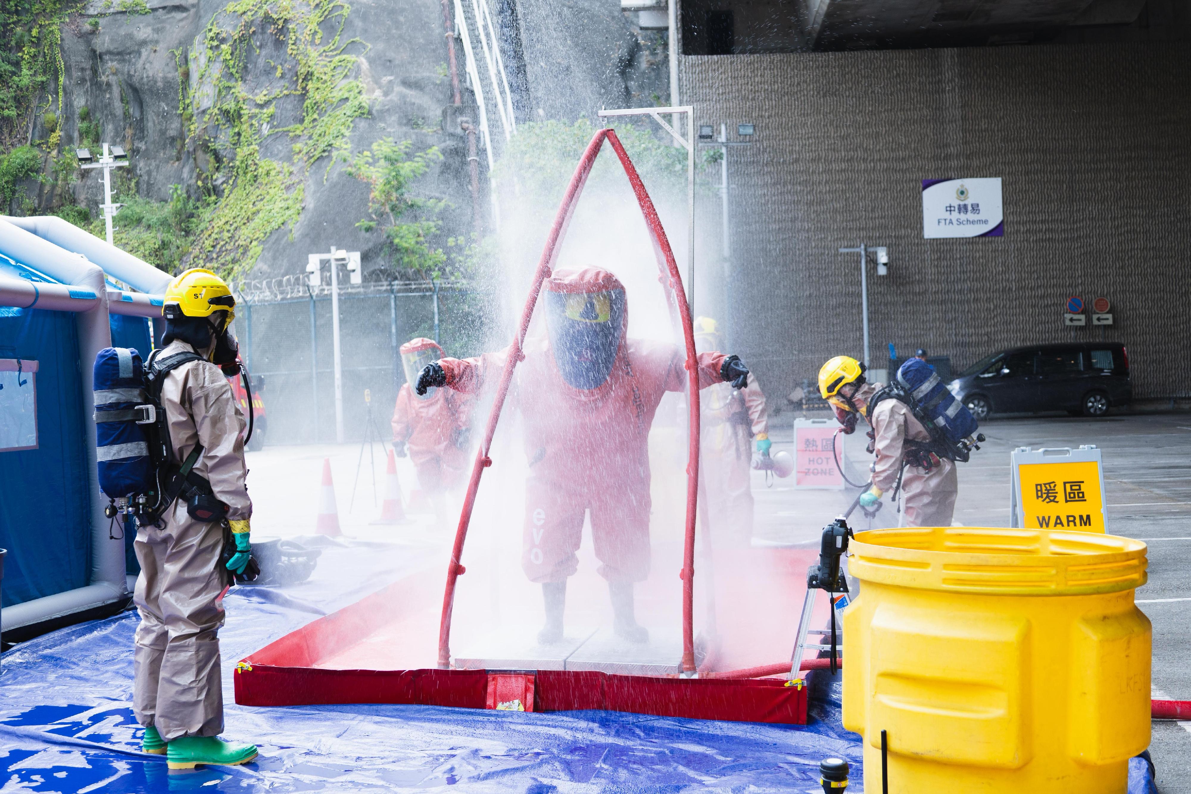 Hong Kong Customs, the Immigration Department and the Fire Services Department (FSD) conducted a joint counter-terrorism intelligence handling and hazardous material incident exercise codenamed "TREADING SEA" this afternoon (July 28) at the Tsing Yi Cargo Examination Compound. Photo shows FSD officers conducting a decontamination procedure.