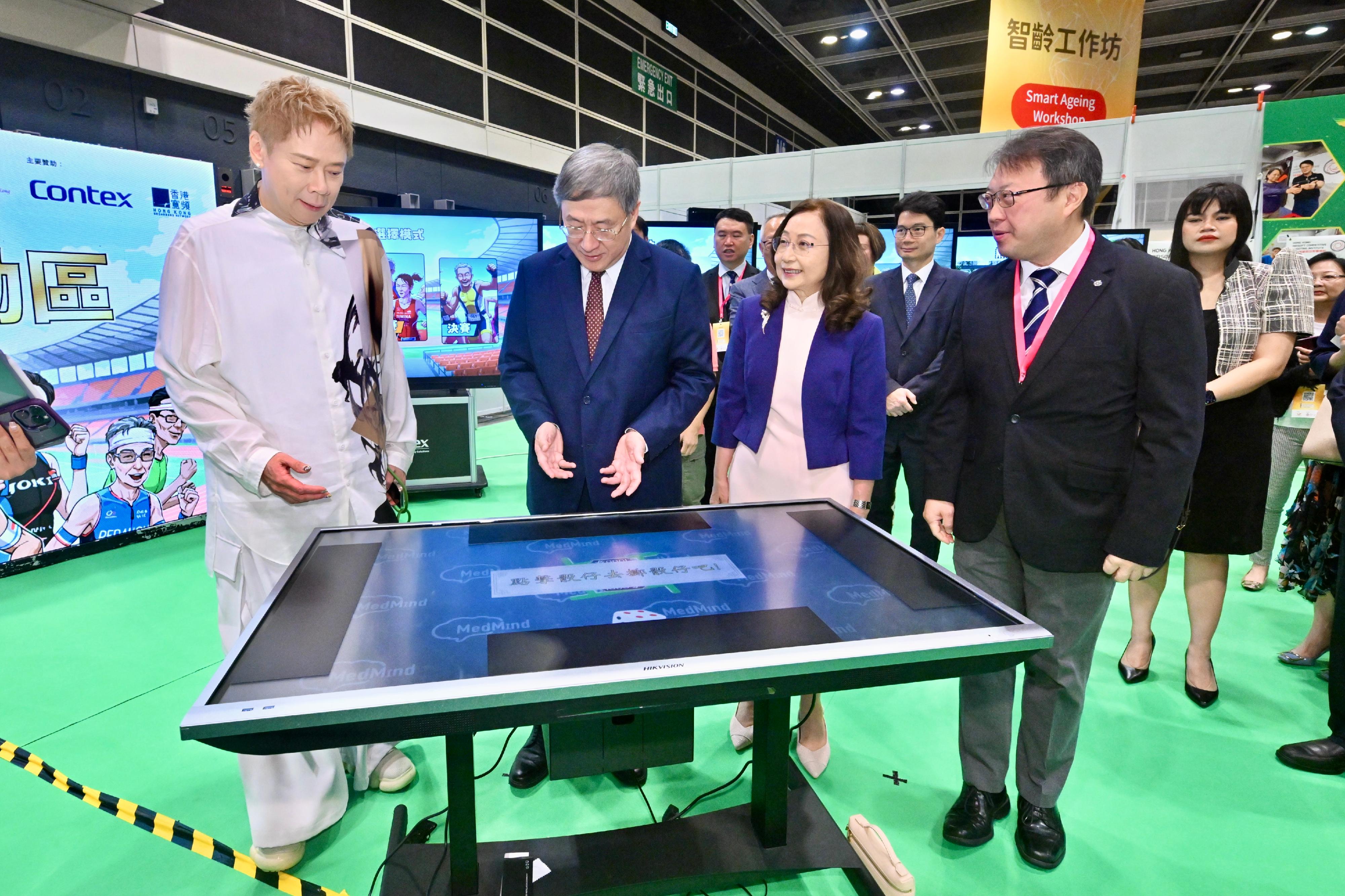 The Deputy Chief Secretary for Administration, Mr Cheuk Wing-hing (second left), tries out smart mahjong specially designed for the elderly at Smart Ageing Sport Zone of the BOC Life 10th Golden Age Expo today (July 31).
