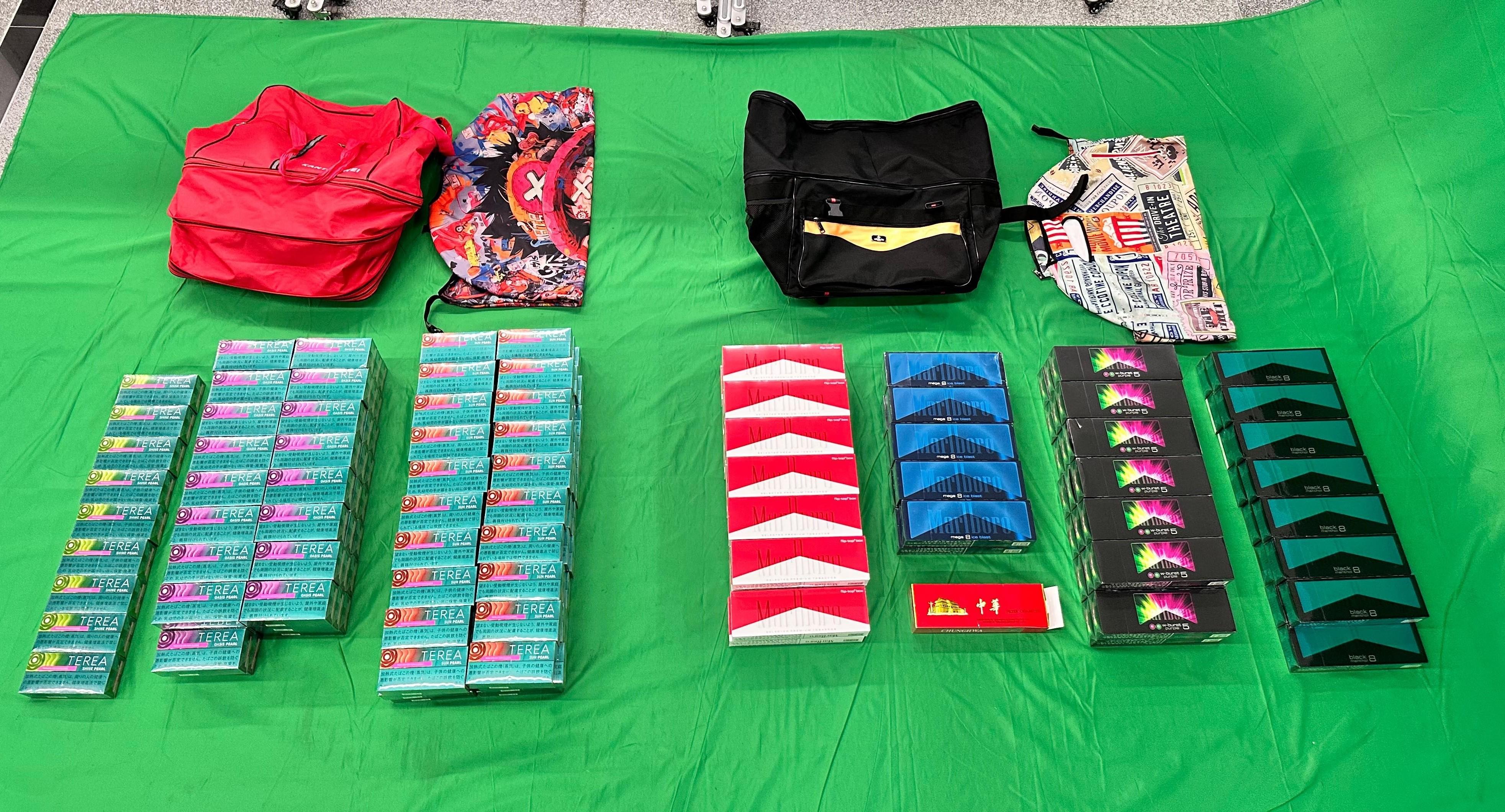 三名入境男旅客因進口或管有未完稅香煙，未有向海關人員作出申報，以及進口另類吸煙產品，分別於昨日（七月三十日）及今日（七月三十一日）在西九龍裁判法院被判處監禁三至七個月以及罰款一千至二千元。其中一名三十歲入境旅客因管有未完稅香煙和未有向海關人員作出申報，以及進口另類吸煙產品，違反《應課稅品條例》和《進出口條例》，昨日被判處監禁三個月和罰款一千元。圖示檢獲的未完稅香煙及另類吸煙產品。
