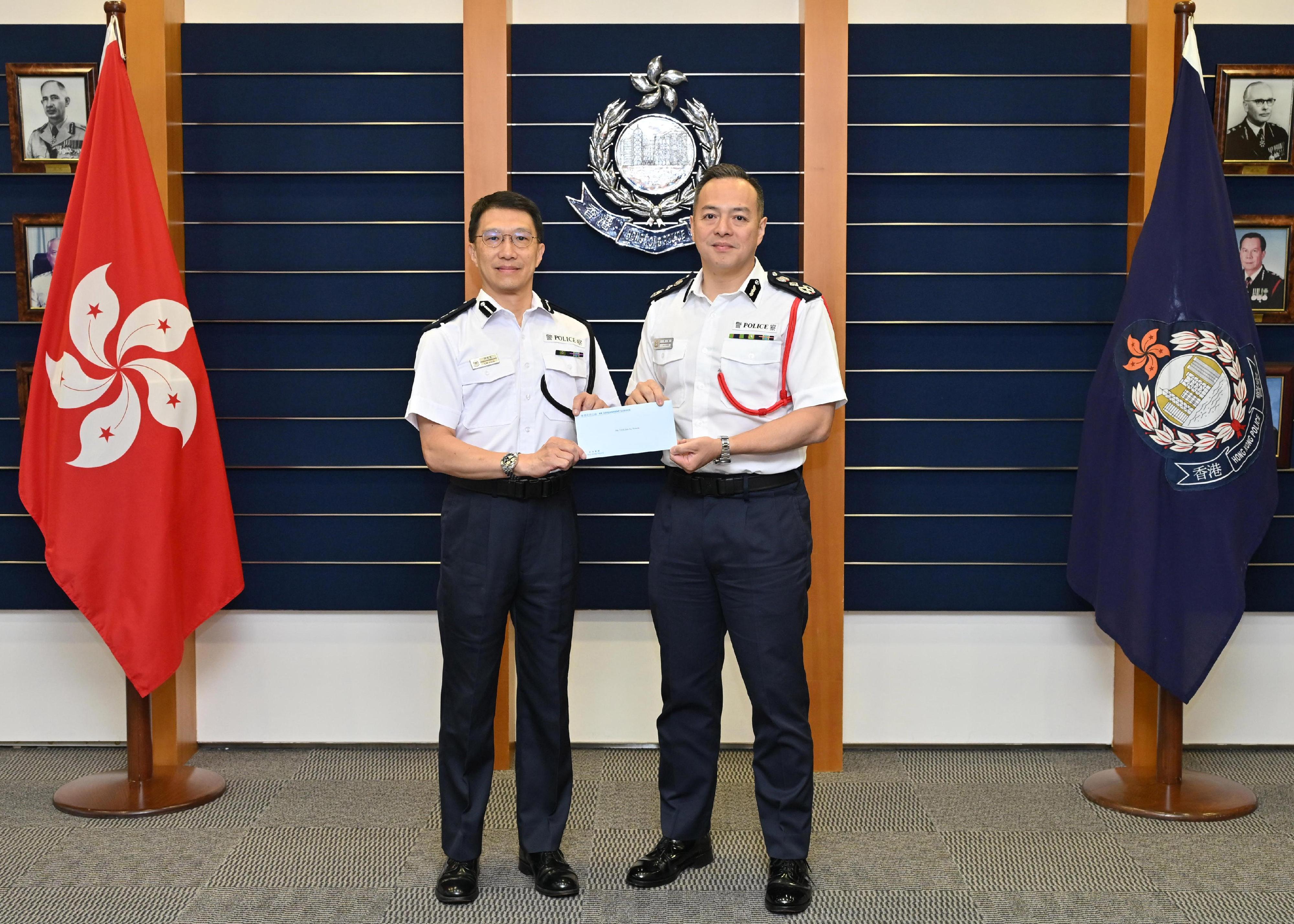 Newly appointed Deputy Commandant of the Hong Kong Auxiliary Police Force, Mr Simon Lim Jun-fu (left), receives the appointment letter from the Commissioner of Police, Mr Chow Yat-ming (right).