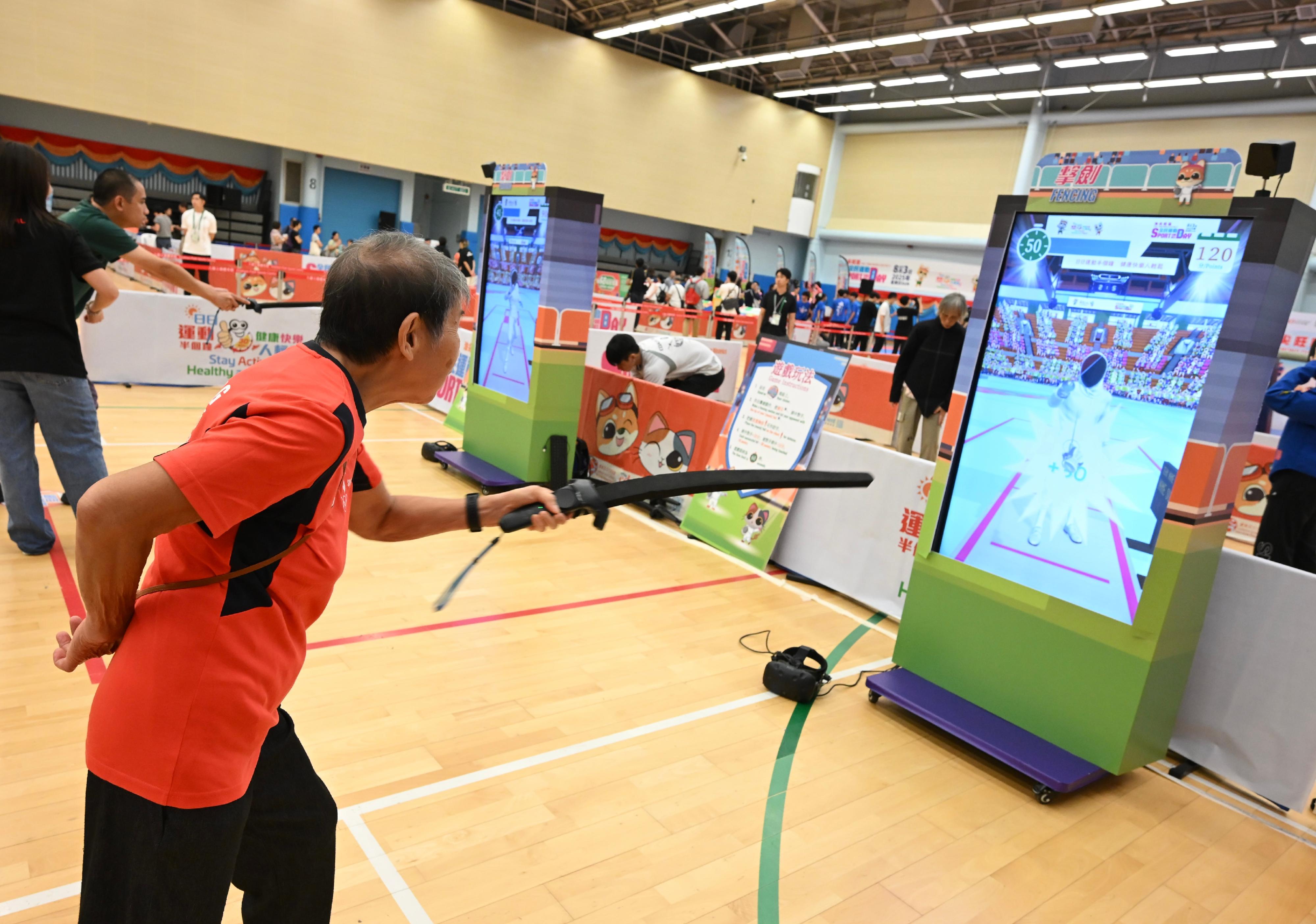 The Sport For All Day 2025 was held by the Leisure and Cultural Services Department today (August 3) with free recreation and sports programmes at designated sports centres in 18 districts for the public to join. Photo shows members of the public taking part in the virtual fencing game. 