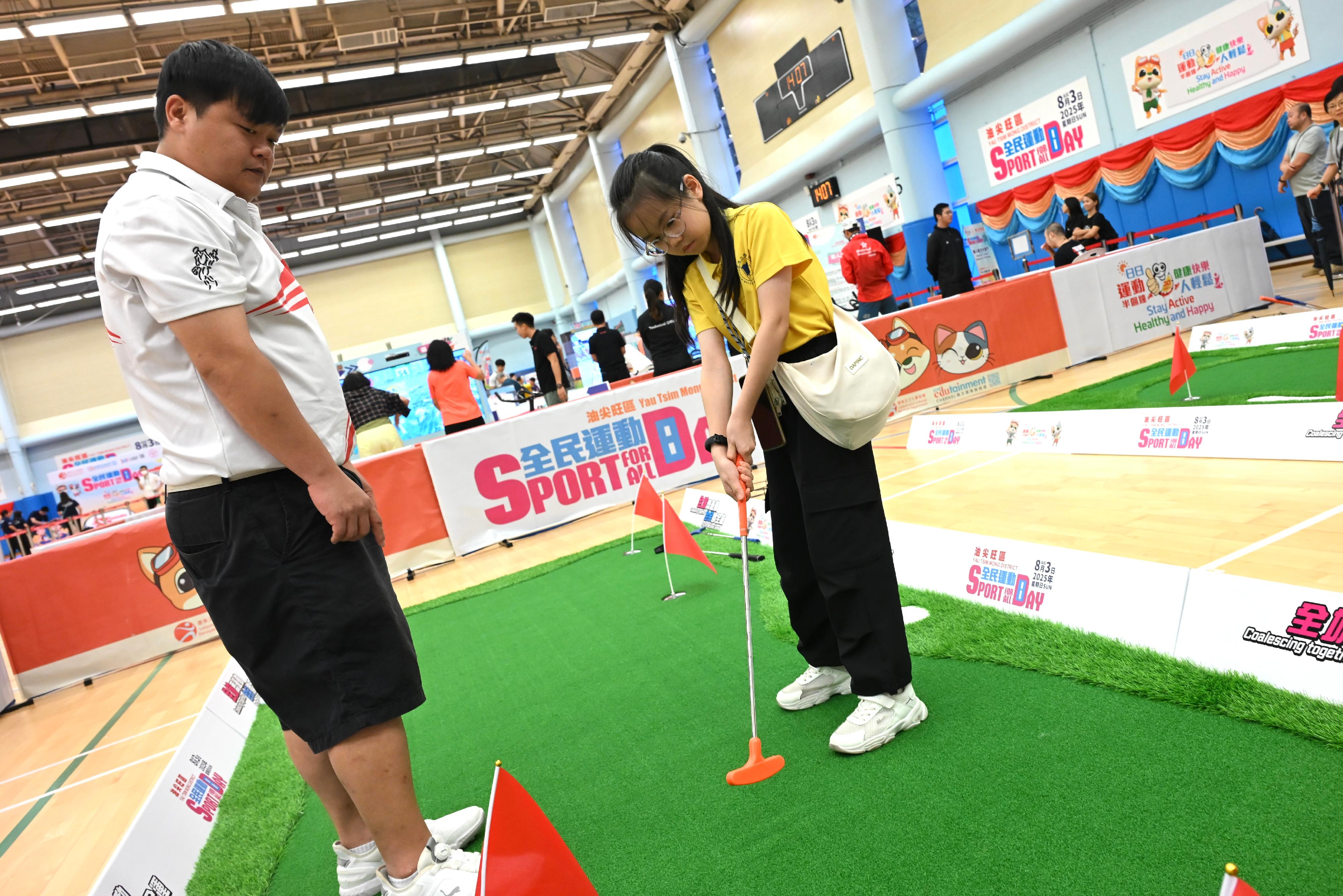 The Sport For All Day 2025 was held by the Leisure and Cultural Services Department today (August 3) with free recreation and sports programmes at designated sports centres in 18 districts for the public to join. Photo shows members of the public taking part in the golf game. 