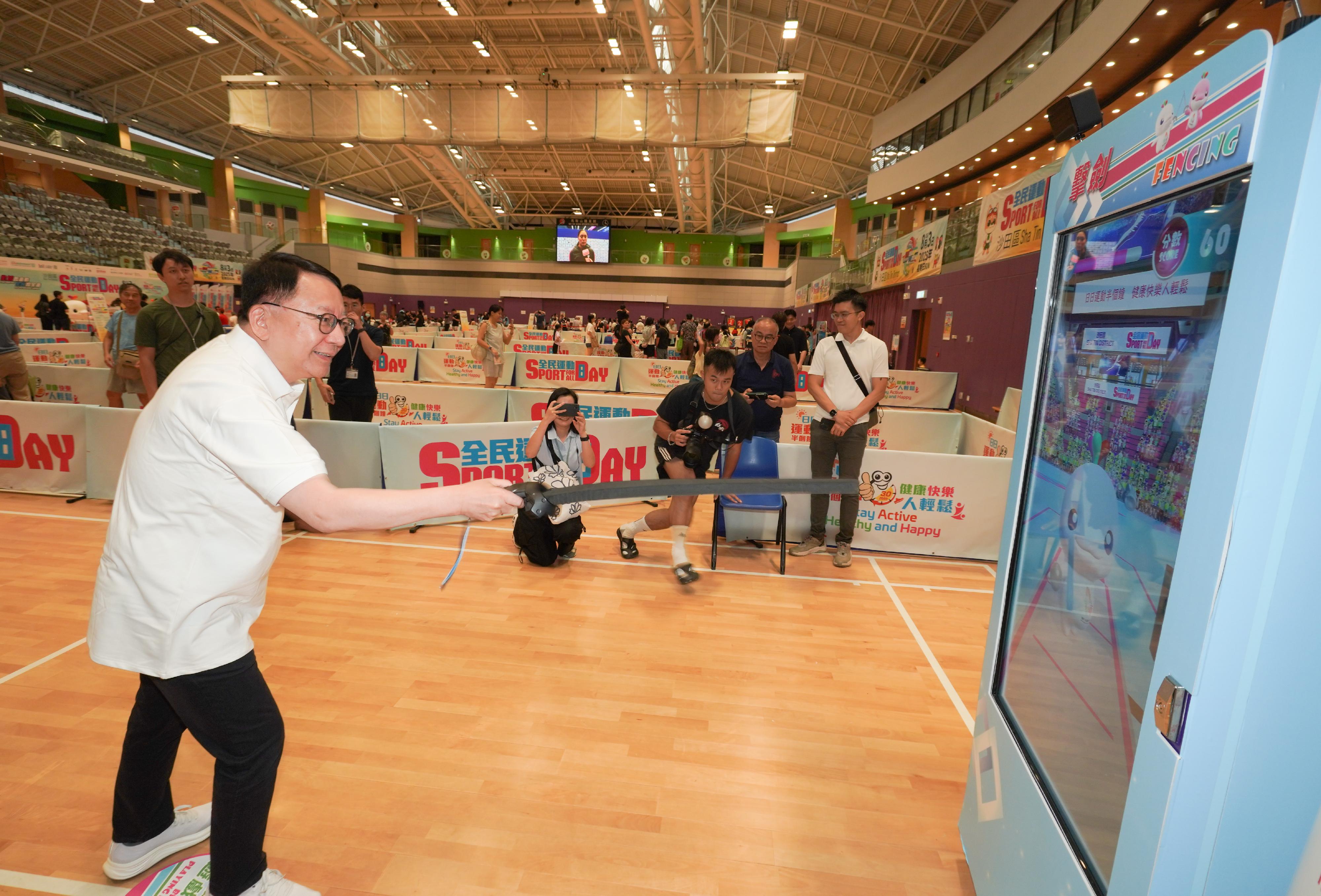 The Chief Secretary for Administration, Mr Chan Kwok-ki, attended the Sport for All Day 2025 held by the Leisure and Cultural Services Department this afternoon (August 3) at the Ma On Shan Sports Centre to promote the message of regular exercising for health. Photo shows Mr Chan (first left) participating in electronic virtual fencing.