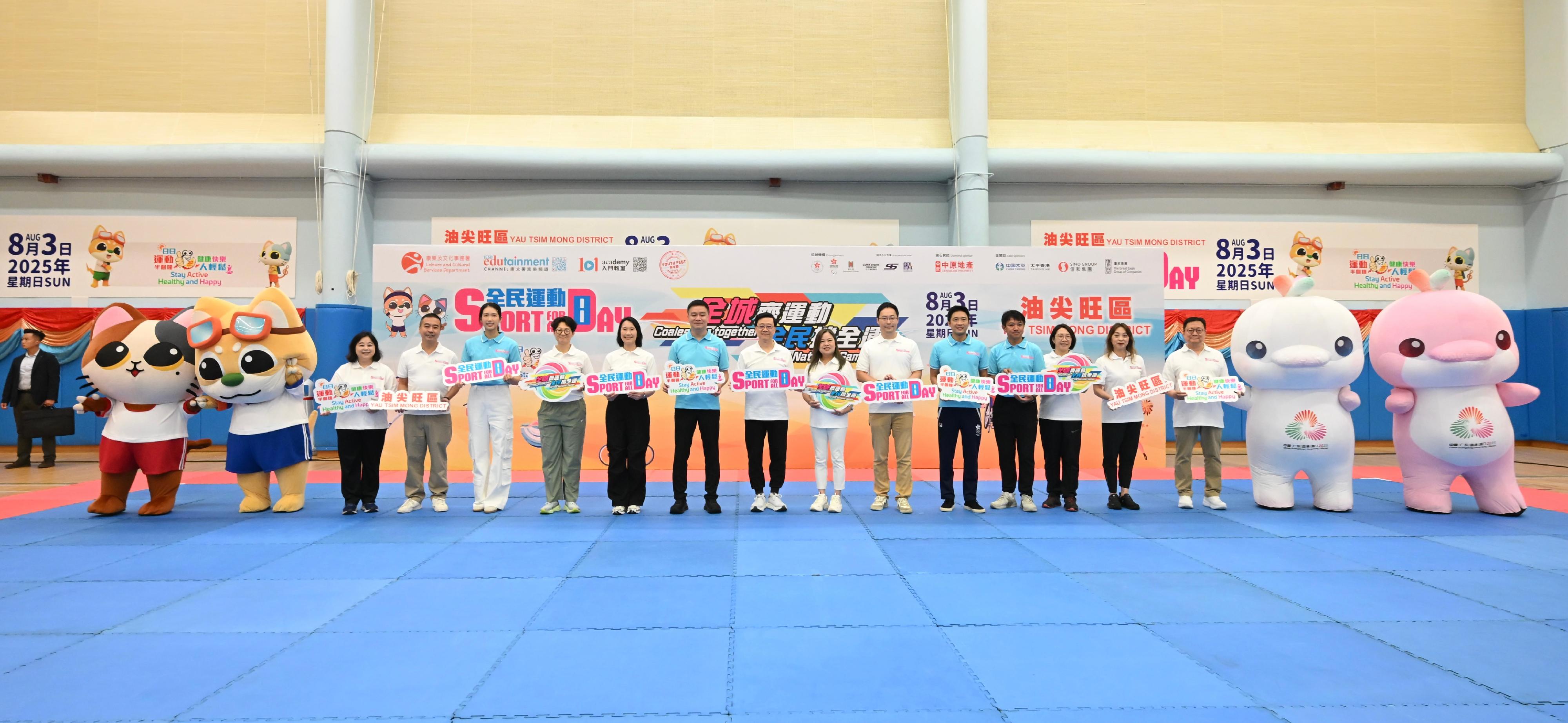 The Chief Executive, Mr John Lee, this afternoon (August 3) attended activities at the Kowloon Park Sports Centre main venue of the Sport For All Day (SFAD) 2025 held by the Leisure and Cultural Services Department, conveying to the public the benefits of regular exercise for physical and mental well-being. Photo shows (from fourth left) the Deputy Director of Leisure and Cultural Services (Leisure Services), Miss Winnie Chui; the Director of Leisure and Cultural Services, Ms Manda Chan; the Chairman of the Community Sports Committee (CSC), Professor Patrick Yung; Mr Lee; the Secretary for Culture, Sports and Tourism, Miss Rosanna Law; the Commissioner for Sports, Mr George Tsoi; the Vice Chairman of the CSC, Mr Eric Fok, and other guests in front of a display board of the SFAD 2025.
