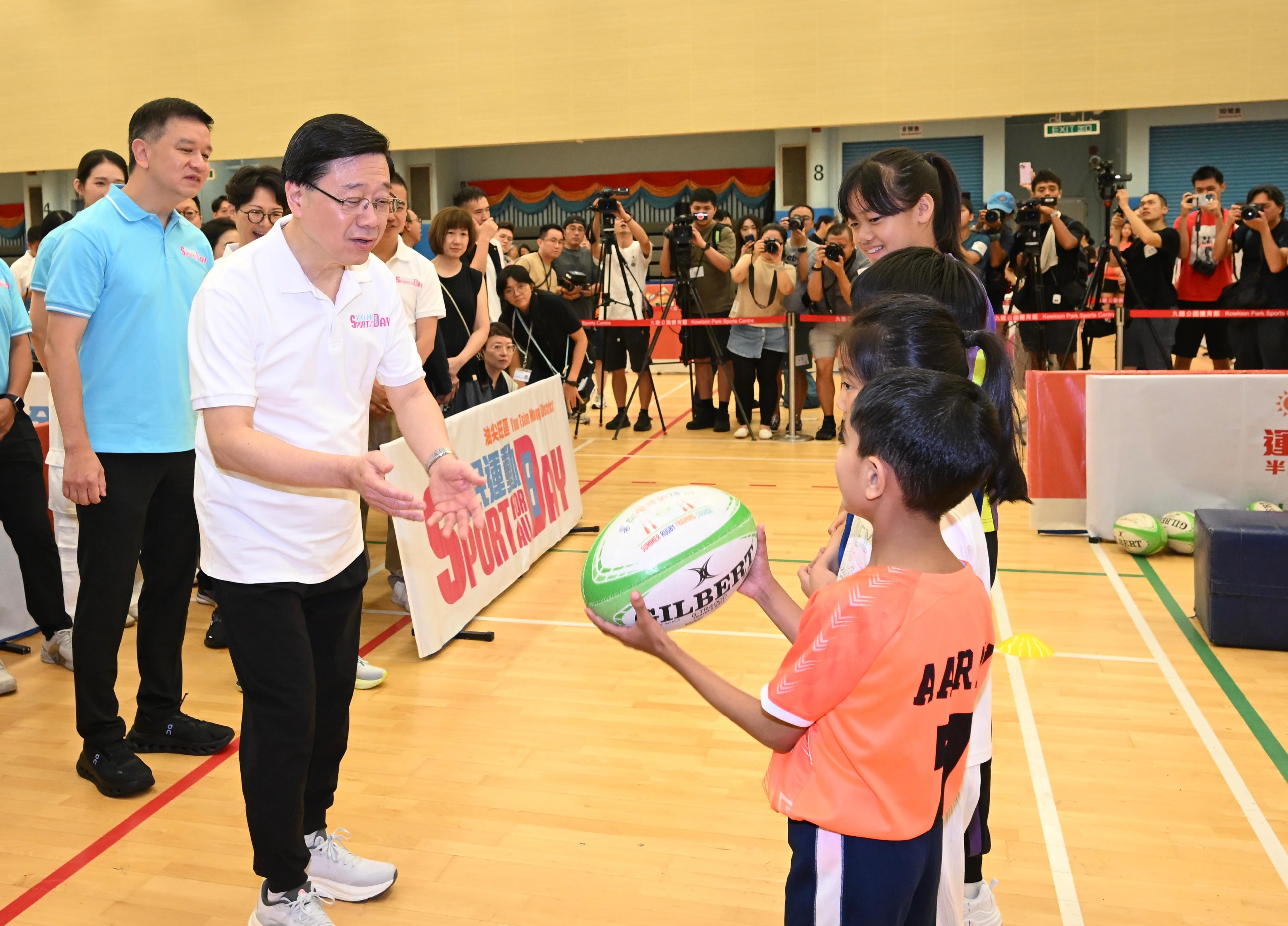 The Chief Executive, Mr John Lee, this afternoon (August 3) attended activities at the Kowloon Park Sports Centre main venue of the Sport For All Day 2025 held by the Leisure and Cultural Services Department, conveying to the public the benefits of regular exercise for physical and mental well-being. Photo shows Mr Lee (second left) participating in a rugby demonstration.
