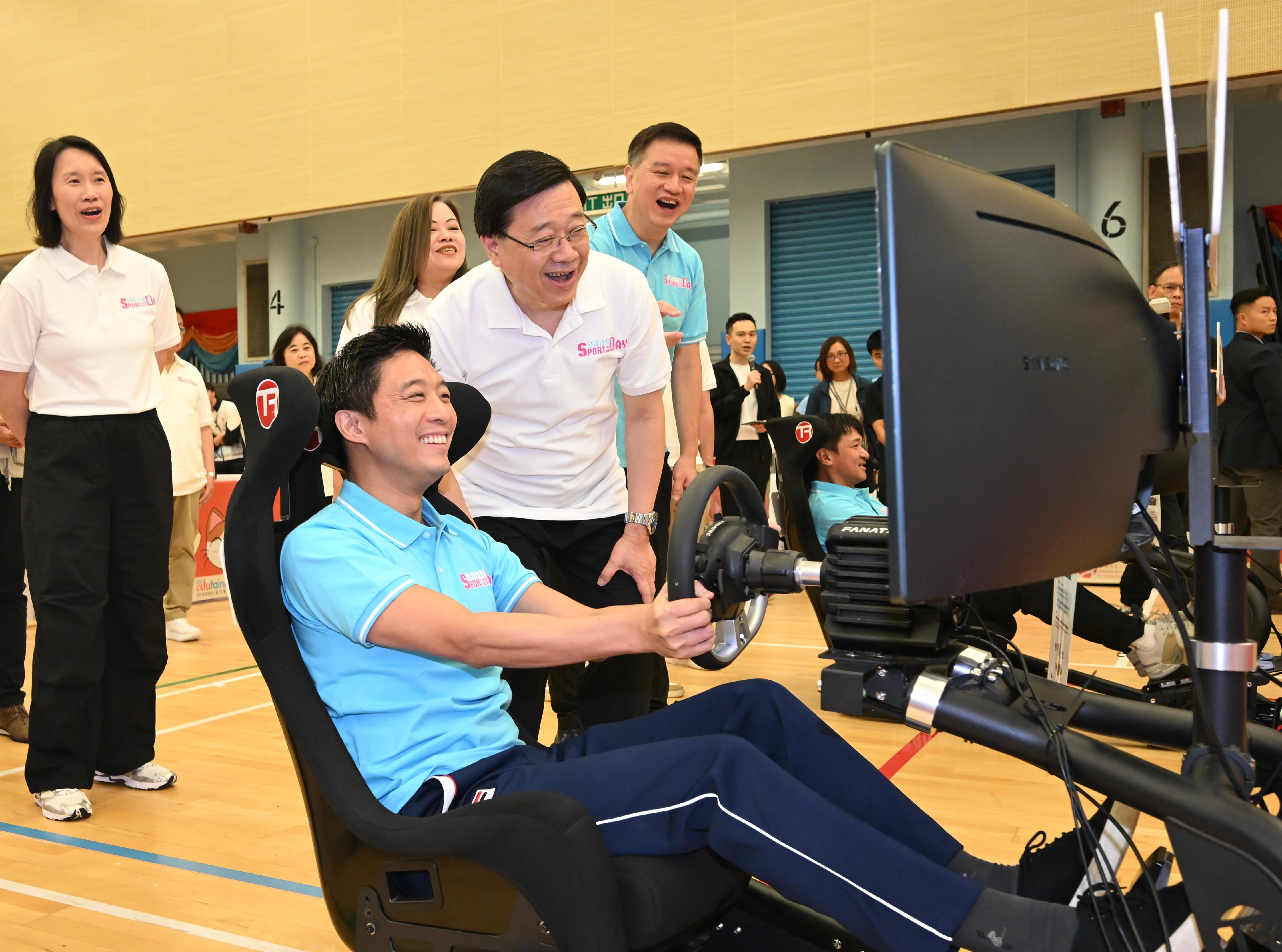 The Chief Executive, Mr John Lee, this afternoon (August 3) attended activities at the Kowloon Park Sports Centre main venue of the Sport For All Day 2025 held by the Leisure and Cultural Services Department, conveying to the public the benefits of regular exercise for physical and mental well-being. Photo shows Mr Lee (second right) and other guests watching a virtual karting game demonstration.