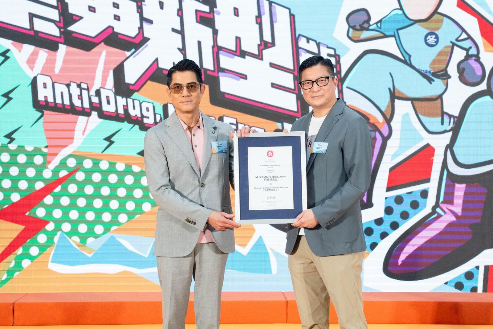 The publicity event "Anti-Drug, New Era" organised by the Narcotics Division of the Security Bureau was held at the Domain shopping mall in Yau Tong this afternoon (August 3). Photo shows the Secretary for Security, Mr Tang Ping-keung (right), appointing renowned artiste Aaron Kwok (left) as "Honorary Commissioner for Narcotics", and presenting an appointment certificate to Aaron Kwok at the event.