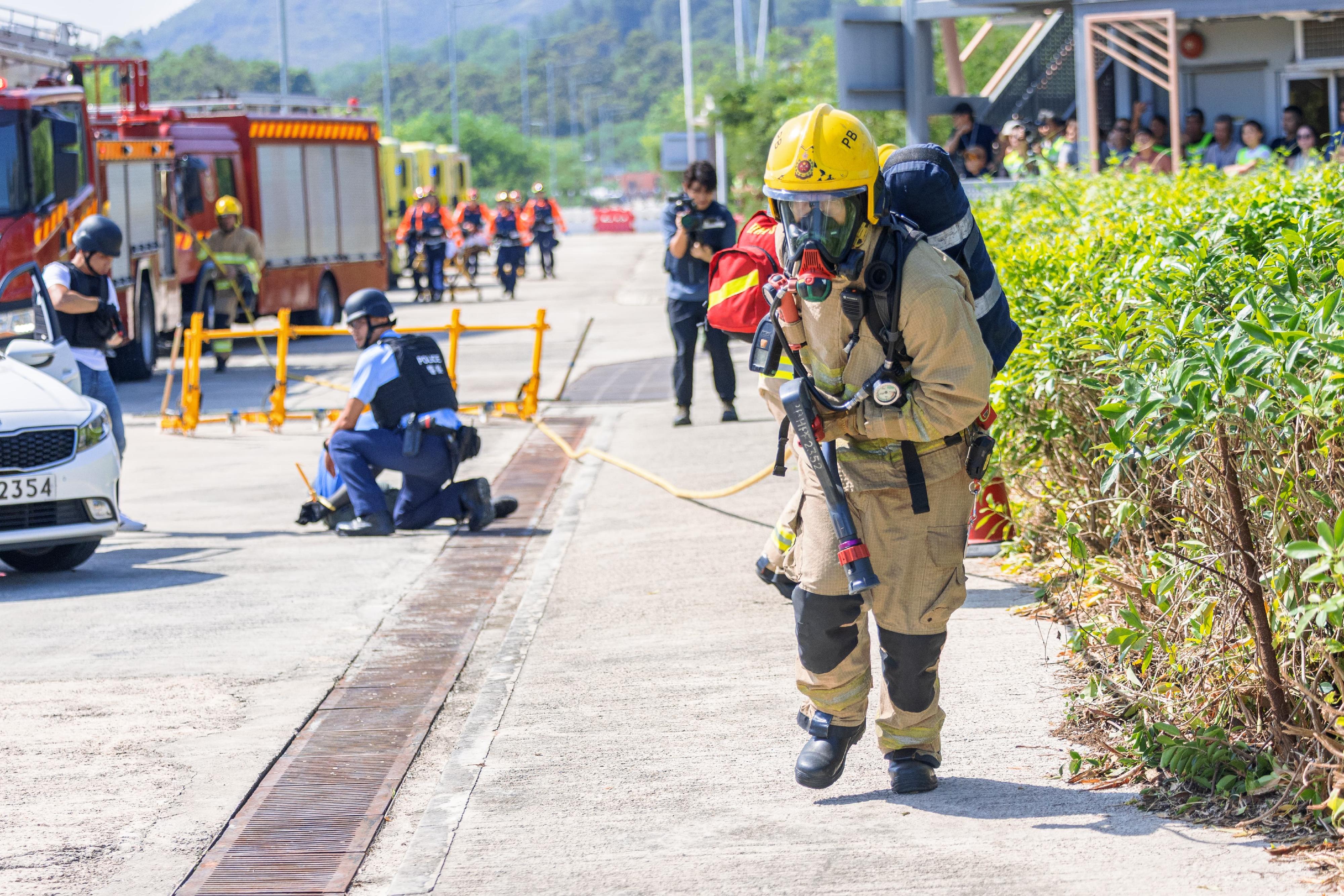 警務處新界南總區衝鋒隊今日（八月八日）在大嶼山幻想道竹篙灣社區隔離設施舉行代號為「飛鷹」、「緗堡」及「雨箭」的跨部門反恐及重大事故演習。圖示消防處人員手持消防喉戒備。