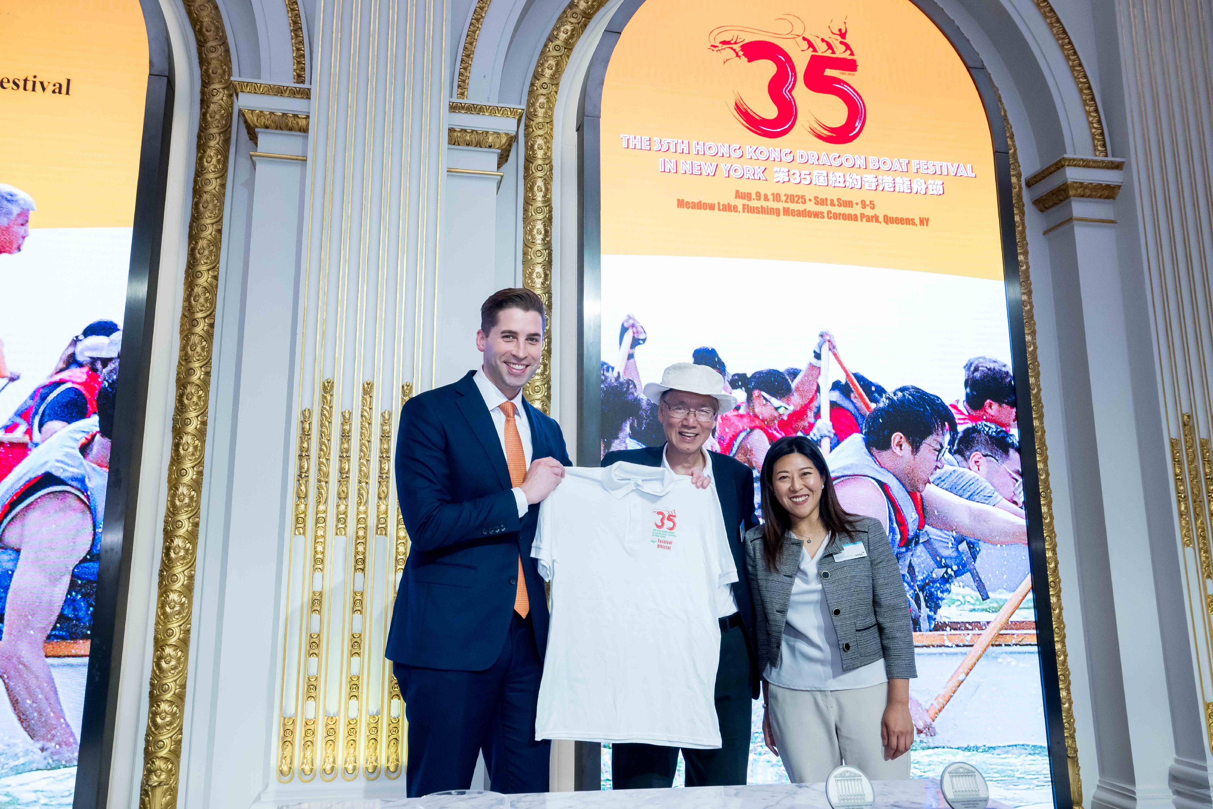 The annual Hong Kong Dragon Boat Festival in New York (HKDBF-NY) marked its 35th anniversary with a vibrant celebration of sport, culture, and community at Meadow Lake, in  Flushing Meadows Corona Park over the weekend (August 9 and 10, New York time). To mark the milestone, the New York Stock Exchange (NYSE) welcomed HKDBF-NY to ring the closing bell on August 8. Photo shows the Director of the Hong Kong Economic and Trade Office, New York, Ms Maisie Ho (right) and the Chairman of the Hong Kong Dragon Boat Festival in New York, Mr Henry Wan (centre) presenting the commemorative 35th anniversary HKDBF-NY t-shirt to the Head of Corporate Affairs of NYSE Mr Will Goodwin. 