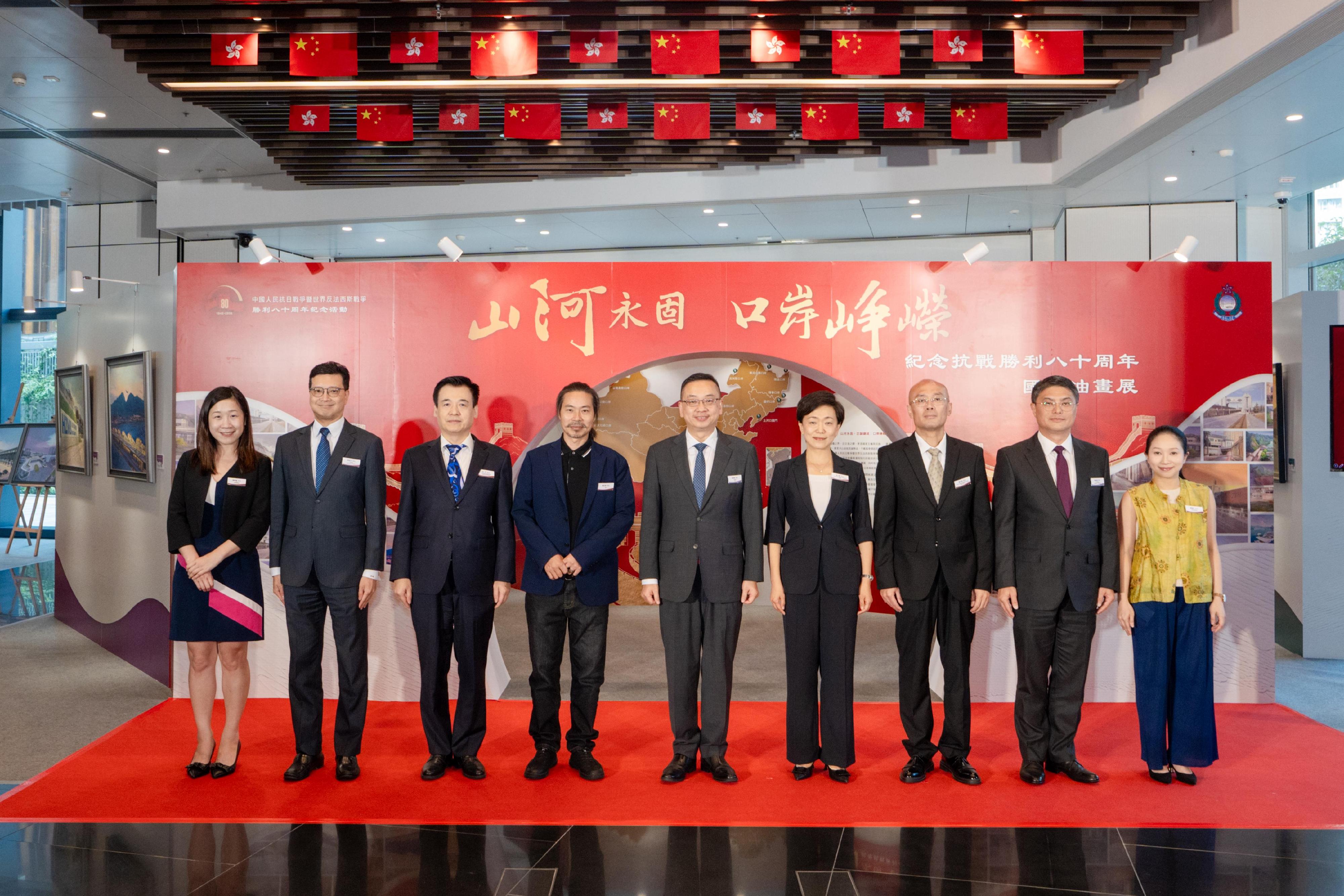 The Immigration Department is holding a six-week oil painting exhibition at the Immigration Headquarters starting from today (August 11) commemorating the 80th anniversary of the victory in the War of Resistance. Photo shows the Director of Immigration, Mr Benson Kwok (fifth right) with the Deputy Director-General of the Police Liaison Department of the Liaison Office of the Central People's Government in the Hong Kong Special Administrative Region, Ms Meng Xiaoyuan (fourth right); the representative of the liaison office of the Office for Safeguarding National Security of the Central People's Government in the Hong Kong Special Administrative Region, Mr Song Yiping (third left); the Director-General of the Consular Department of the Office of the Commissioner of the Ministry of Foreign Affairs in the Hong Kong Special Administrative Region, Mr Wei Wenxiu (third right); the Deputy Director of Immigration (Control, Visa and Documents), Mr Ching Wo-mok (second left); the Deputy Director of Immigration (Enforcement, Systems and Management), Mr Choi Chi-yuen (second right); the Principal Assistant Secretary of Security Bureau, Miss Trista Lim (first left); the District Officer (Sai Kung), Miss Kathy Ma (first right); and painter Yang Yongzhi (fourth left).
