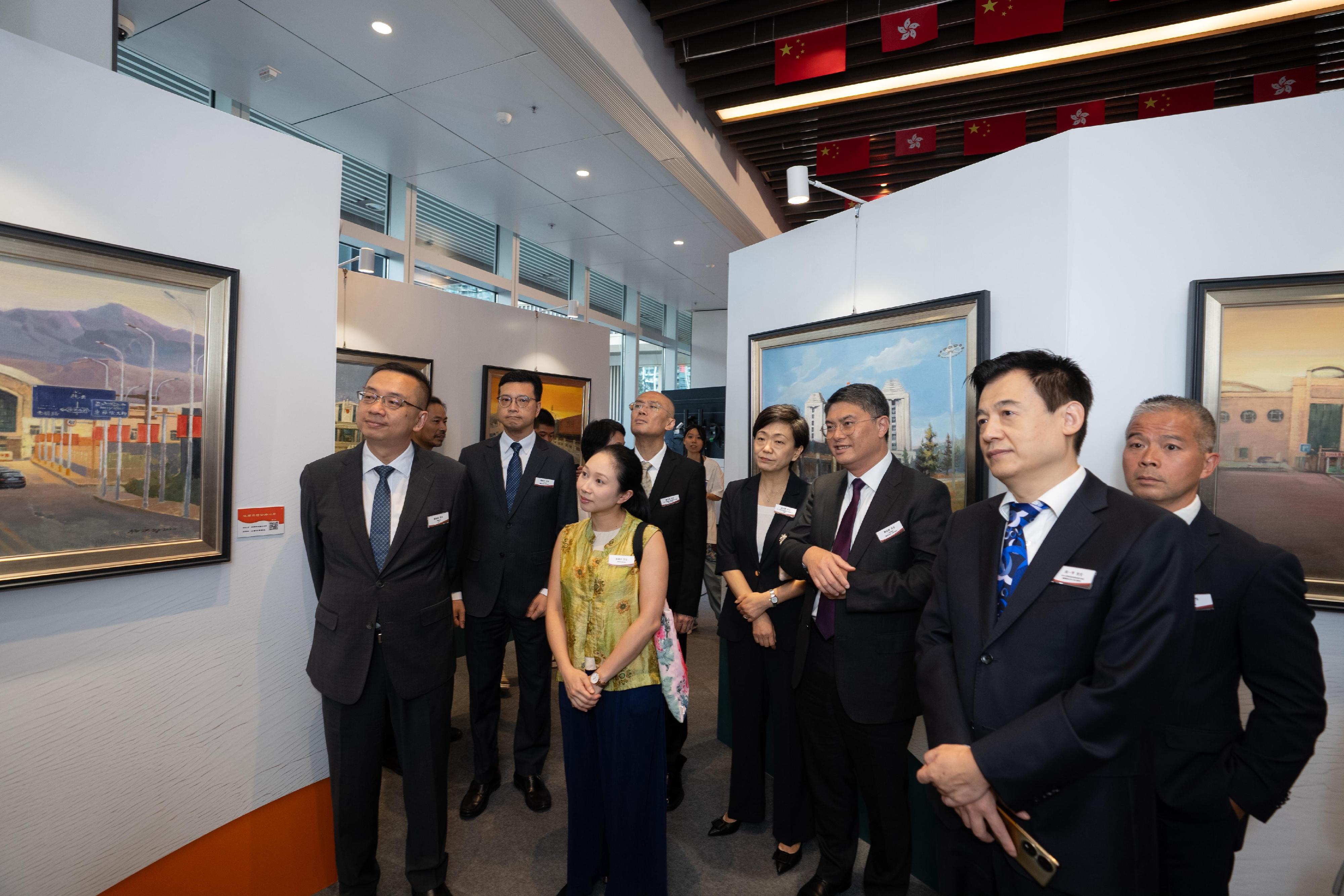 The Immigration Department is holding a six-week oil painting exhibition at the Immigration Headquarters starting from today (August 11) commemorating the 80th anniversary of the victory in the War of Resistance. Photo shows the Director of Immigration, Mr Benson Kwok (first left), and guests visiting the oil painting exhibition.