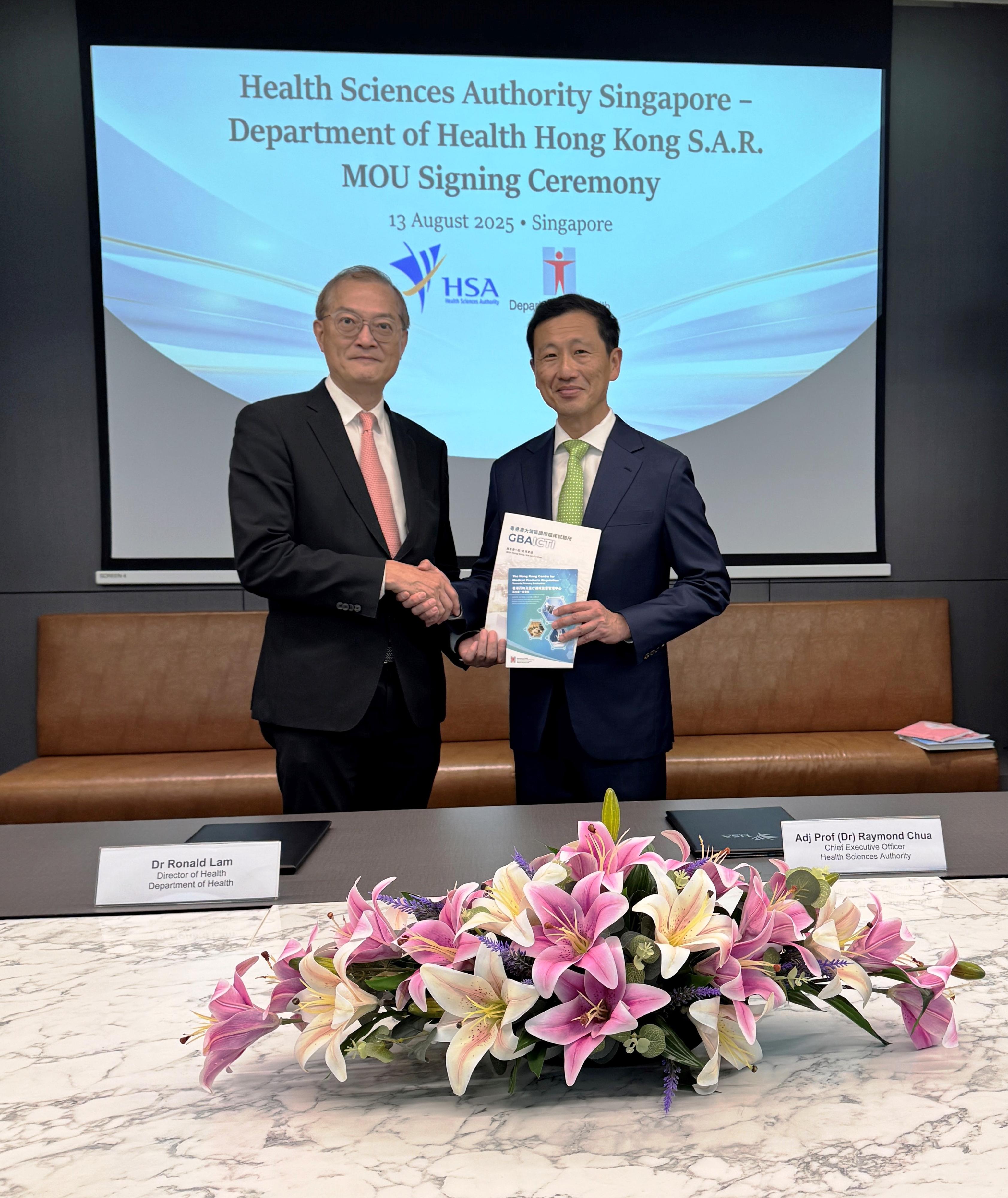The Secretary for Health, Professor Lo Chung-mau, and Singapore's Coordinating Minister for Social Policies and the Minister for Health, Mr Ong Ye Kung, witnessed the signing of a Memorandum of Understanding on regulation of drugs and medical devices and tobacco control policy by the Department of Health and the Health Sciences Authority of Singapore in Singapore today (August 13). Photo shows Professor Lo (left) presenting to Mr Ong (right) brochures on the development of clinical trials and regulation of drugs and medical products in Hong Kong.
