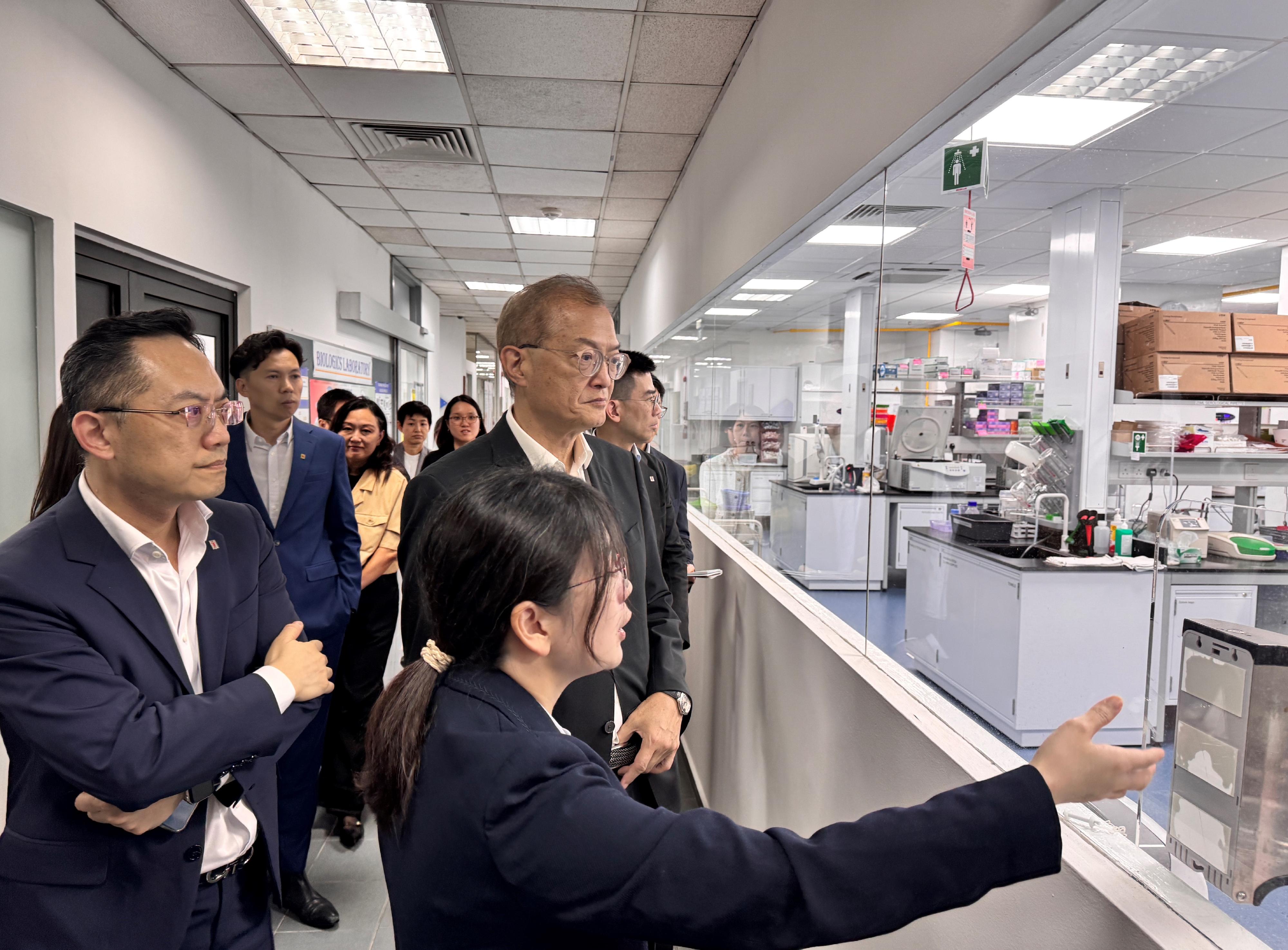 The Secretary for Health, Professor Lo Chung-mau (centre), leads a delegation to Singapore to visit the biologics laboratory of the Health Sciences Authority of Singapore today (August 13). Looking on is the Director of Health, Dr Ronald Lam (first left).